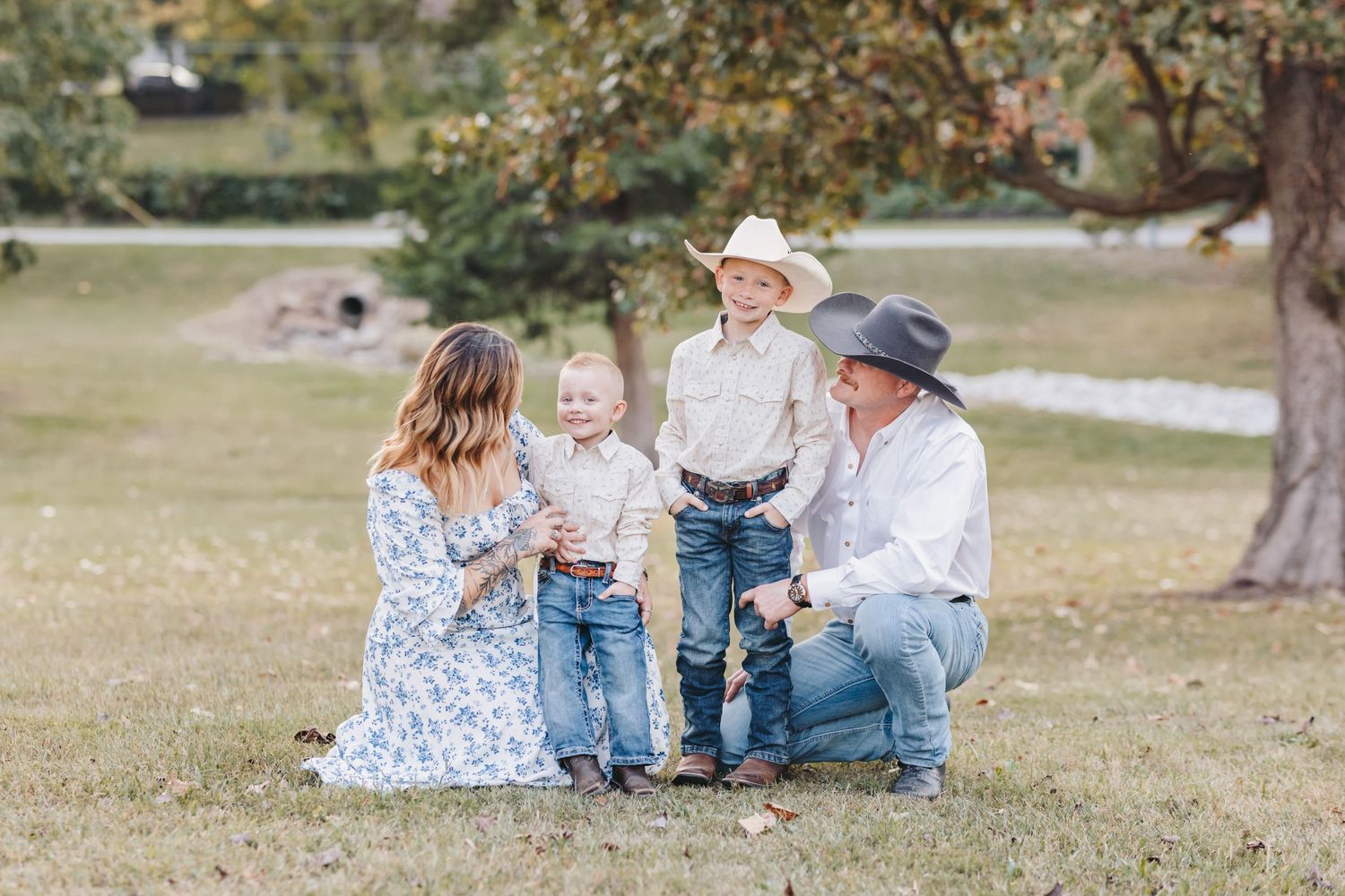 A tender family moment captured during an outdoor photo session in a park.