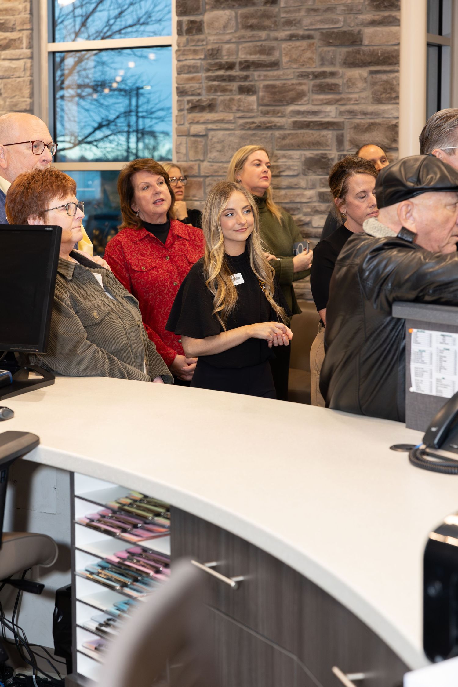 Staff members gathered around a curved desk during an office event.
