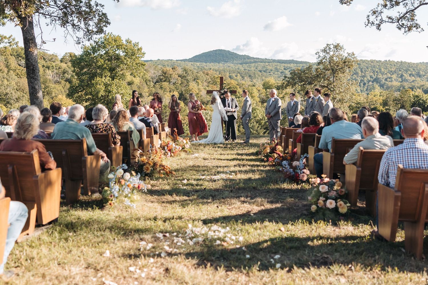 Outdoor wedding ceremony seating arranged in rows with mountain vista in background.