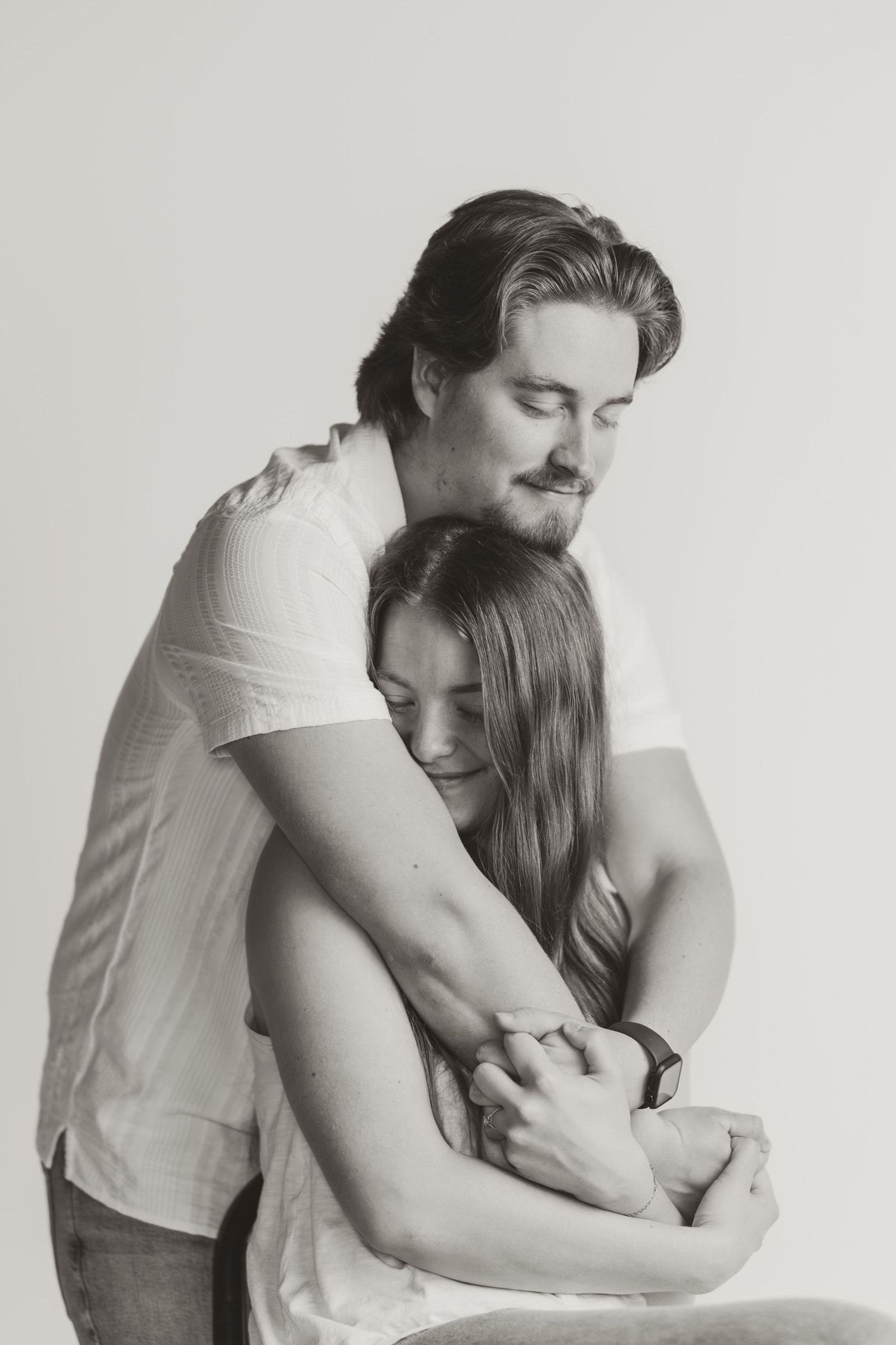 Black and white portrait of couple in tender embrace.