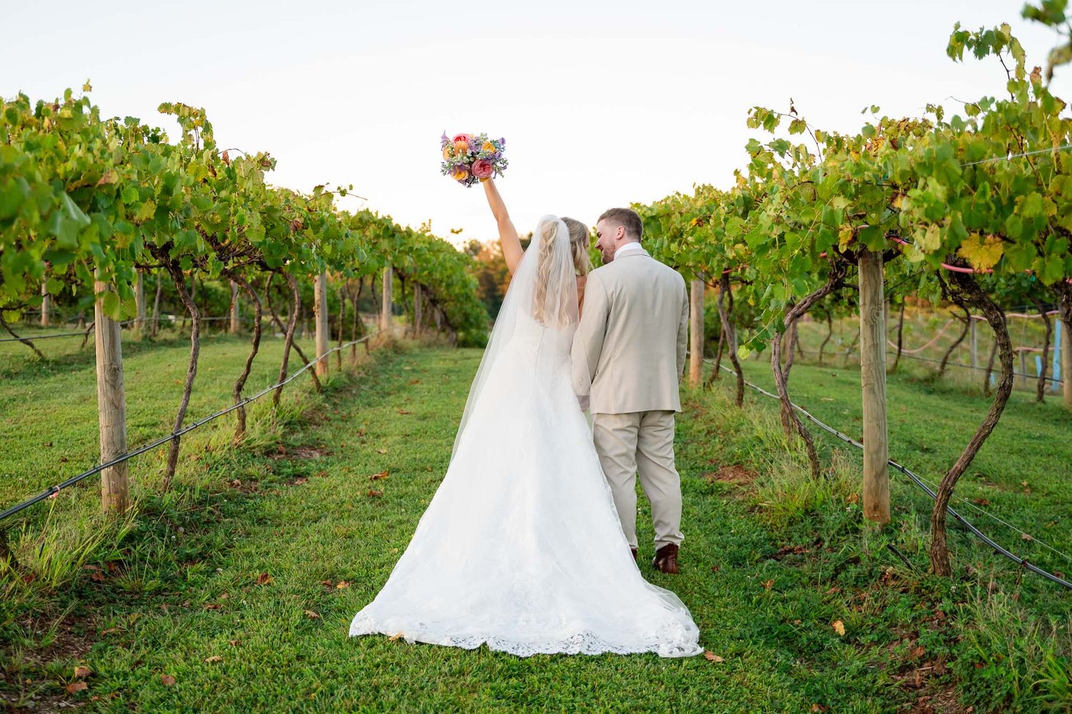 romantic bridal portrait in a vineyard setting with colorful bouquet and natural light