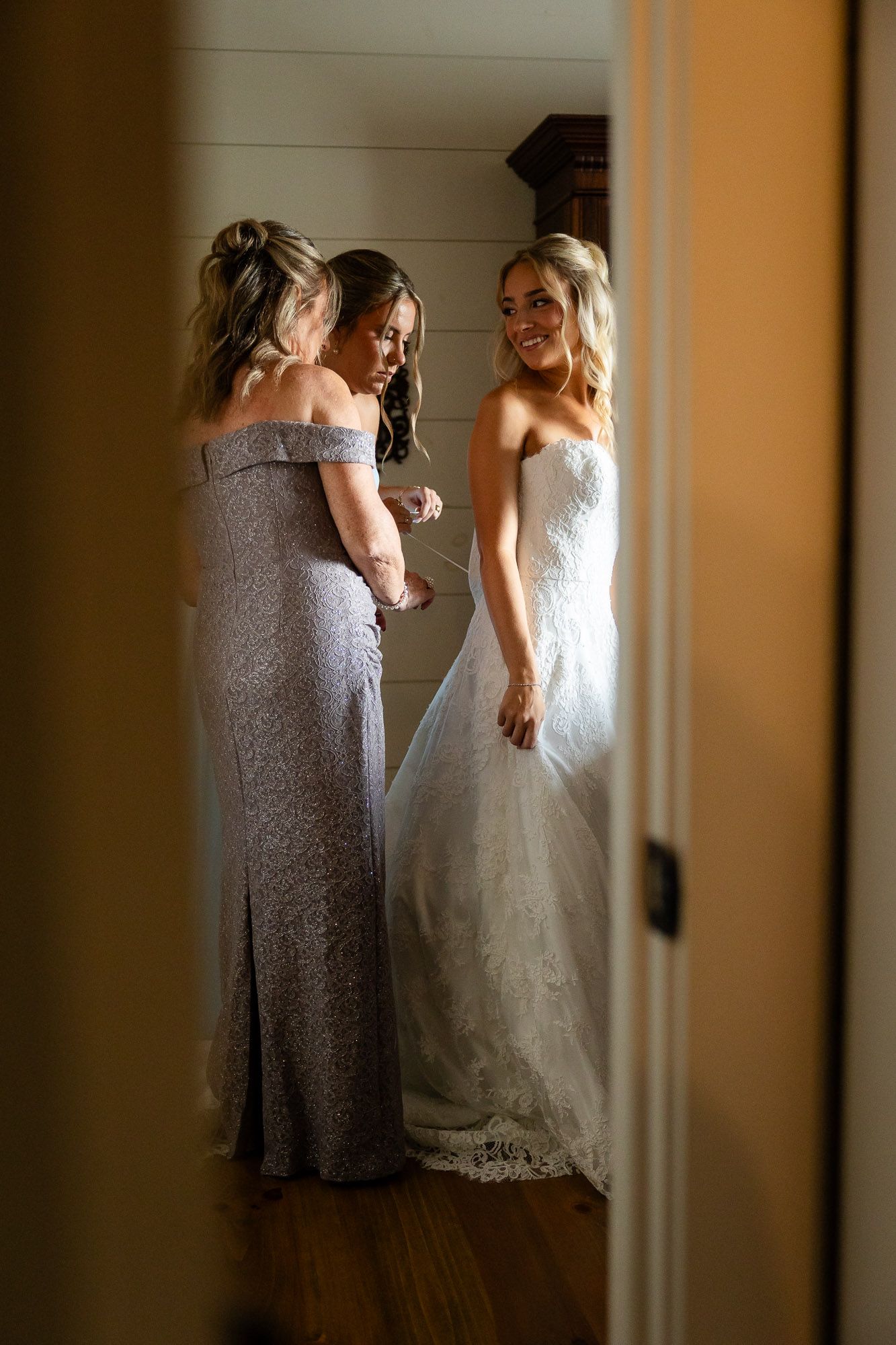 photo of a mother of the bride helping the bride in her dress for her wedding in atlanta georgia
