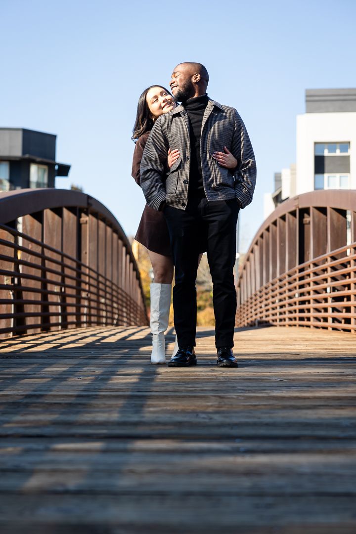 Playful engagement shoot with a couple laughing at the Millennium Gate museum