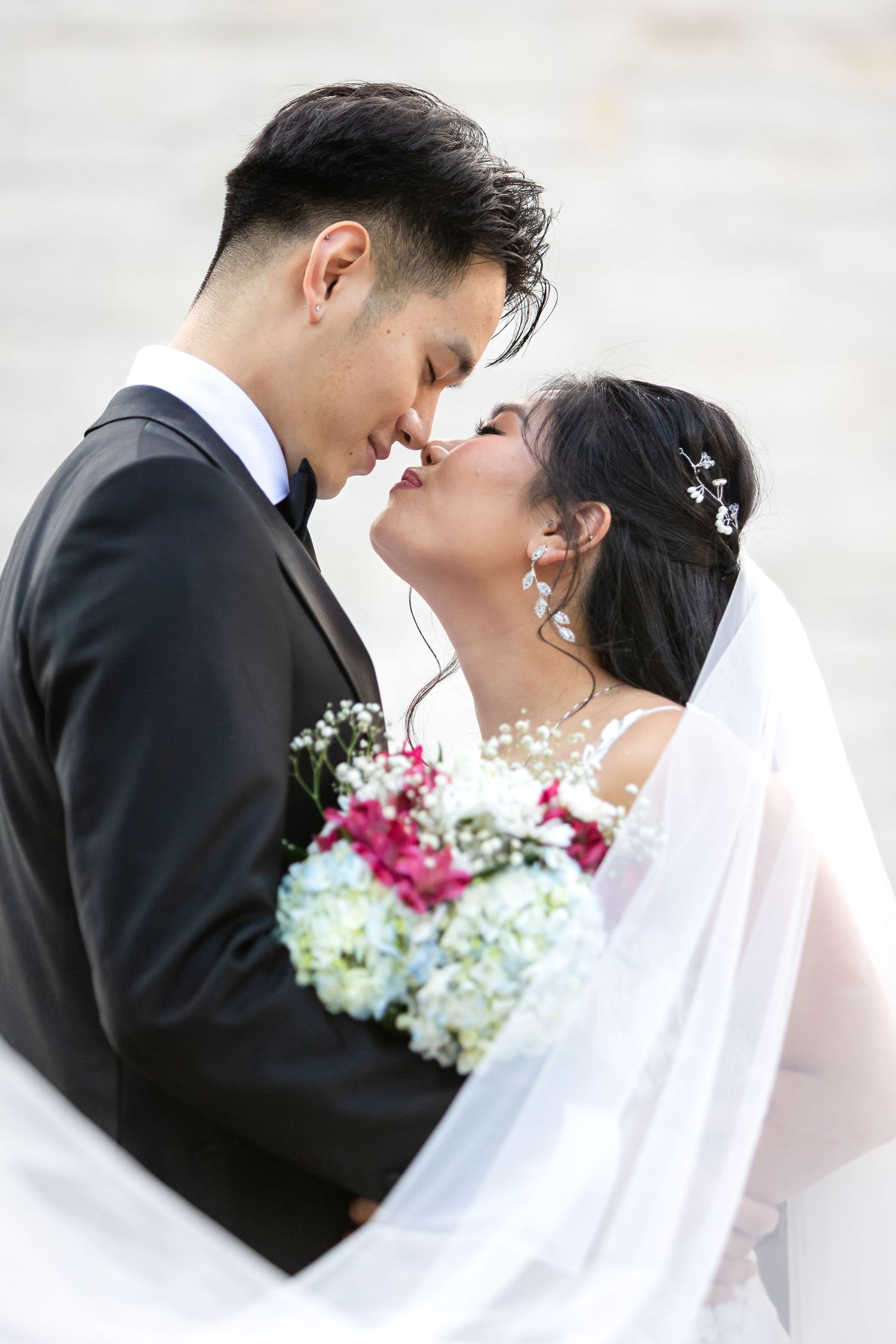 A bridal couple sharing a romantic moment on their wedding day at Ashton Gardens