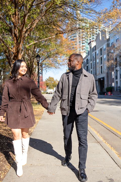 candid photo of a couple walking during their engagement shoot at the Millennium Gate Museum