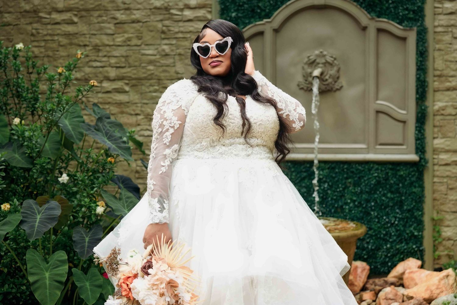 Bride in wedding gown posing by stone archway at The Castle at Wildwood Gardens in Georgia