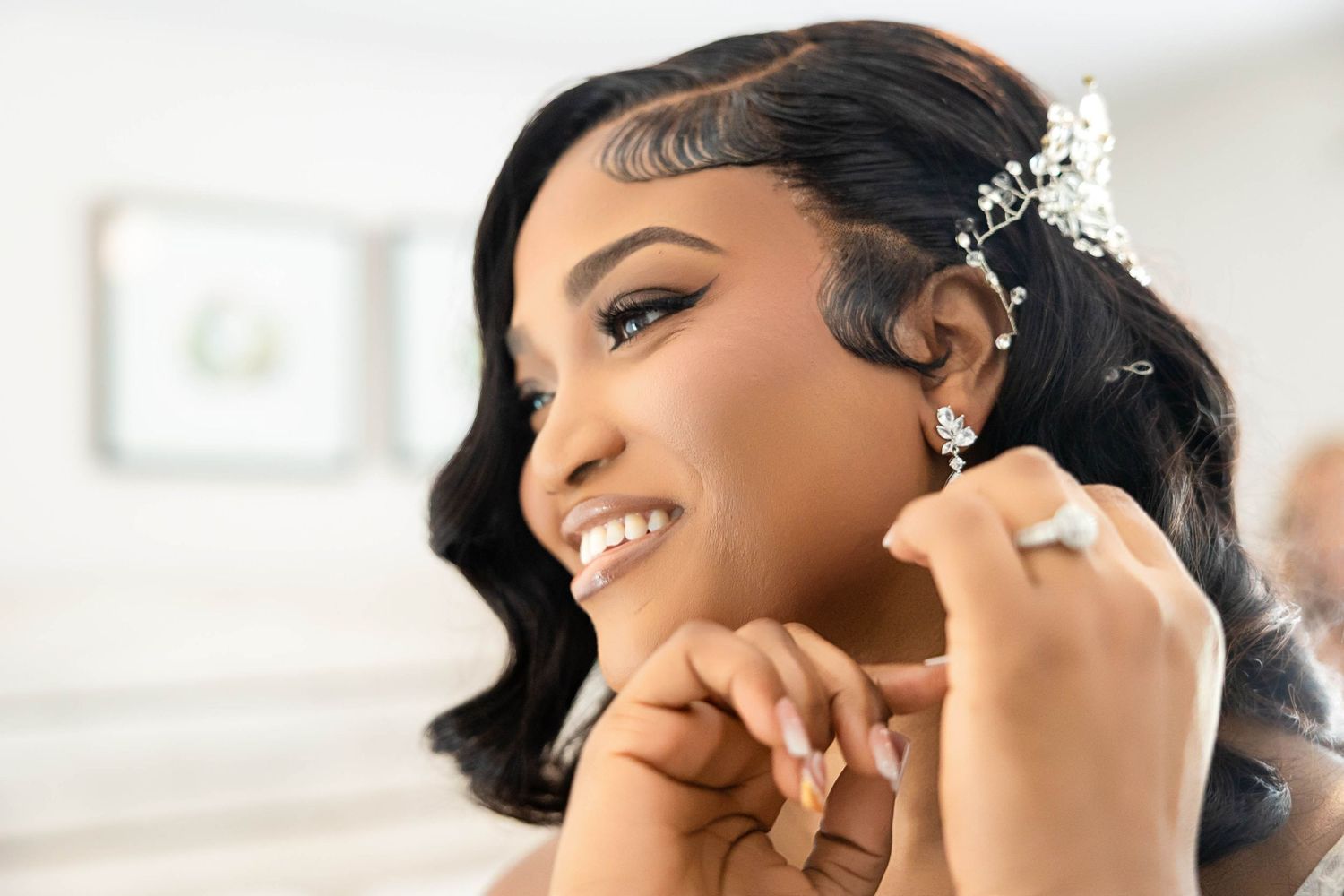 Bride getting final adjustments to her delicate pearl hair accessories and elegant hairstyle on her wedding day.