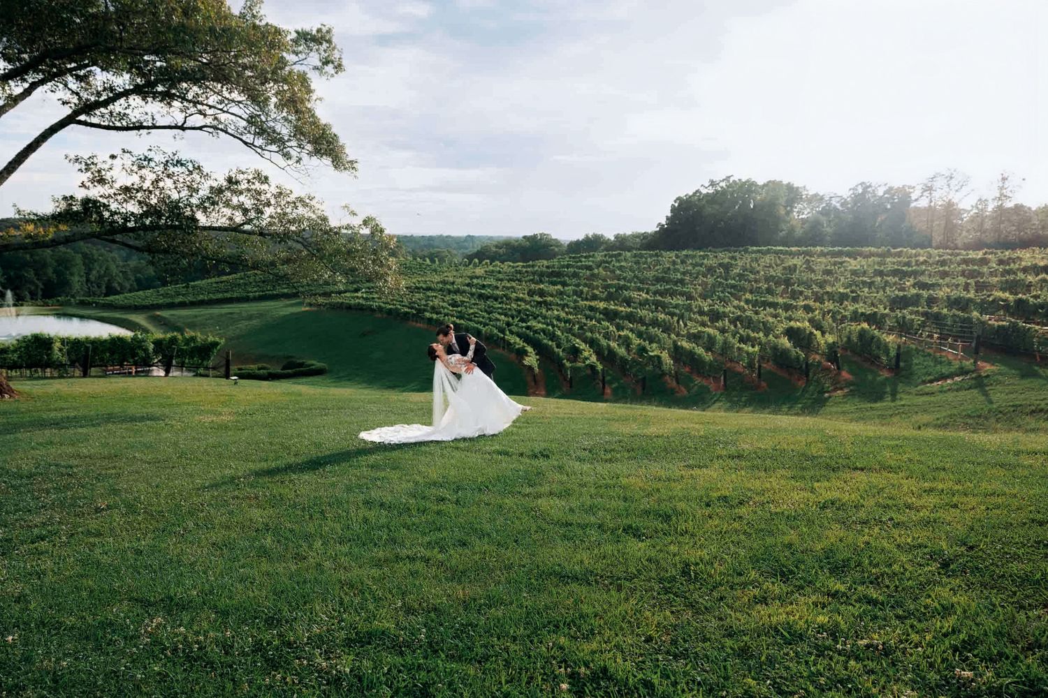 Bride and groom dancing on lush green lawn at Montaluce Winery & Restaurant, vineyard during golden hour wedding.