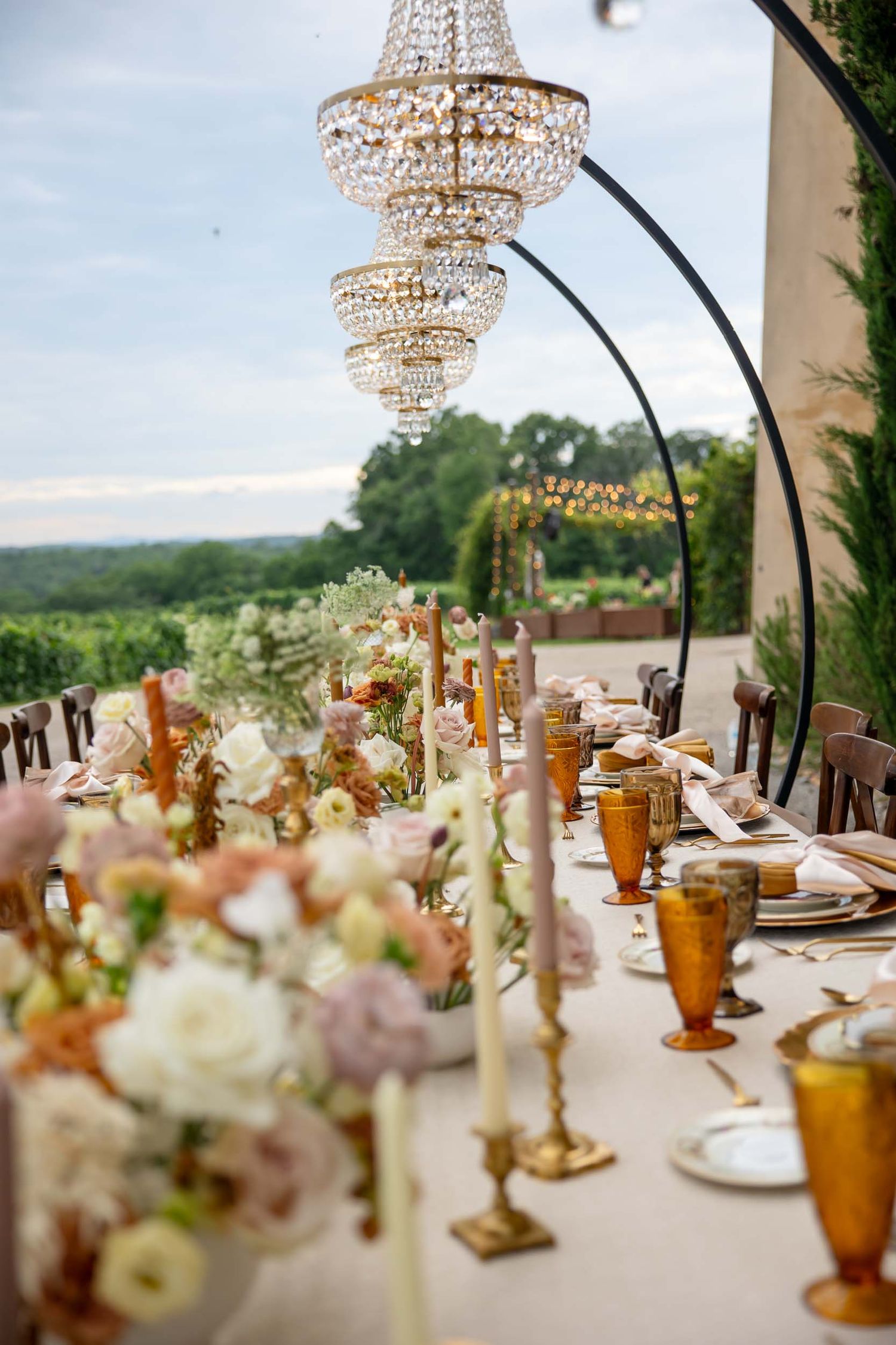 Elegant outdoor wedding reception with crystal chandelier, amber goblets, gold candlesticks, at montaluce winery & restaurant
