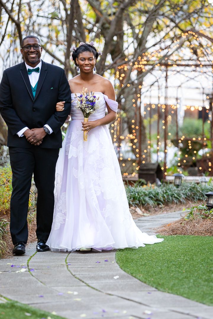 father walks his daughter on her wedding day at Four Oaks Manor