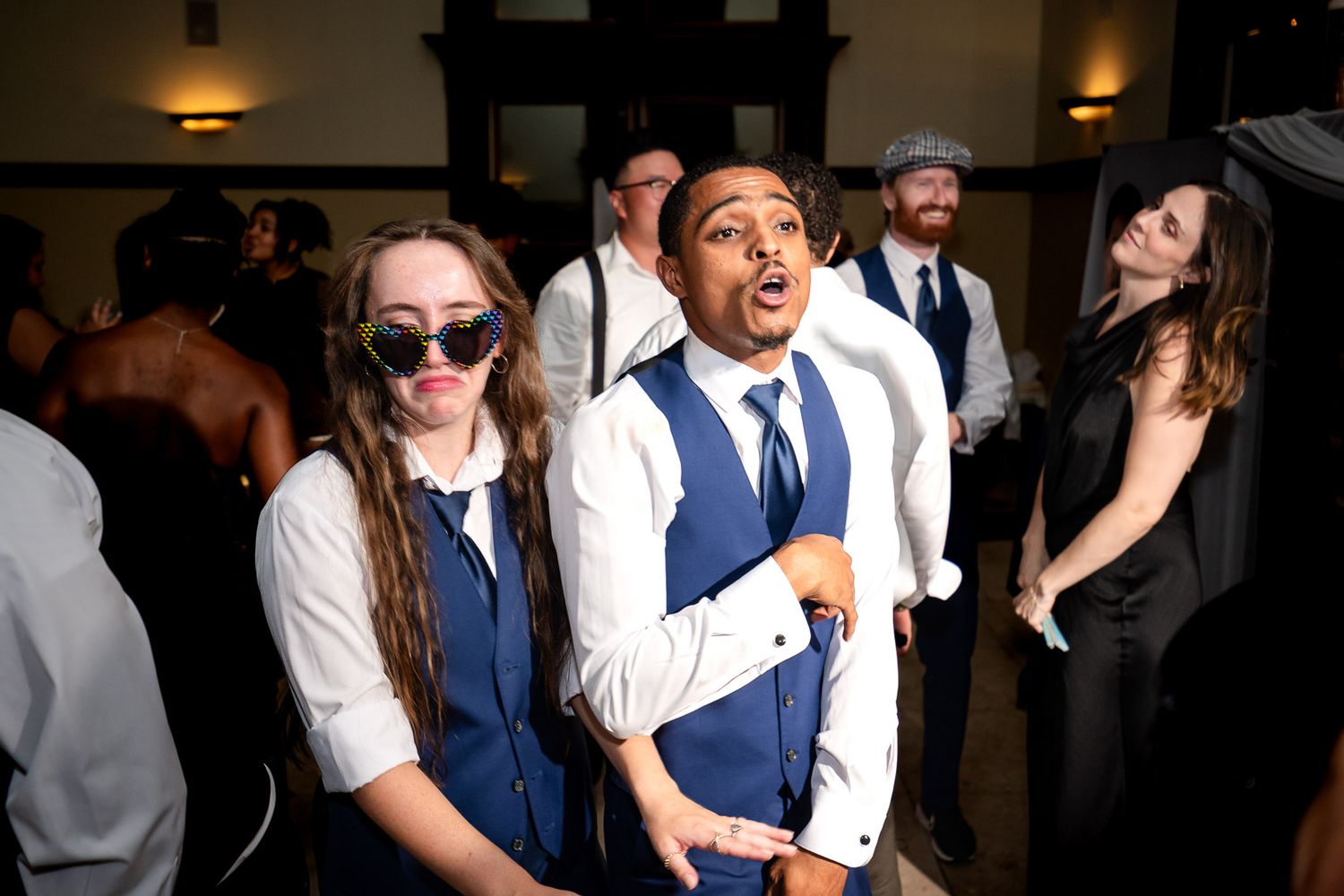 Guests dancing and celebrating at a wedding reception in formal attire.