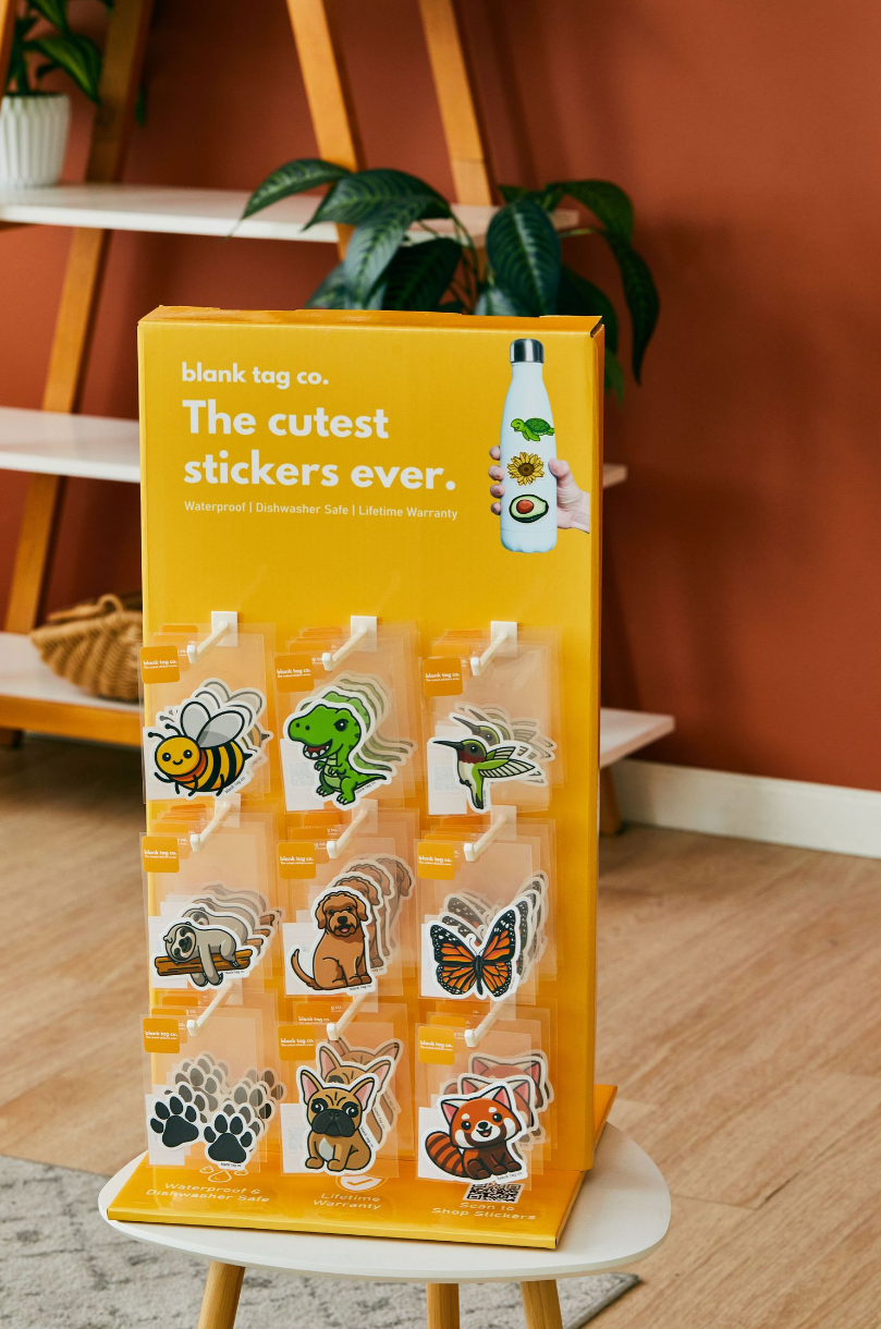 Yellow display stand showing colorful animal and insect stickers featuring bees, butterflies and other creatures.