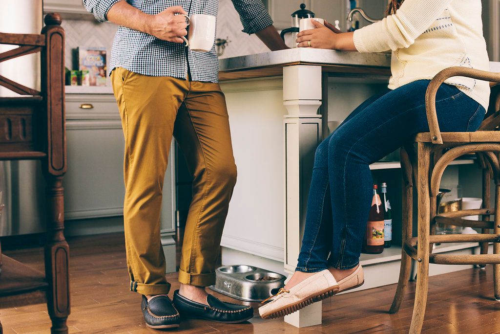 Two people's feet visible while sitting at kitchen counter on bar stools.
