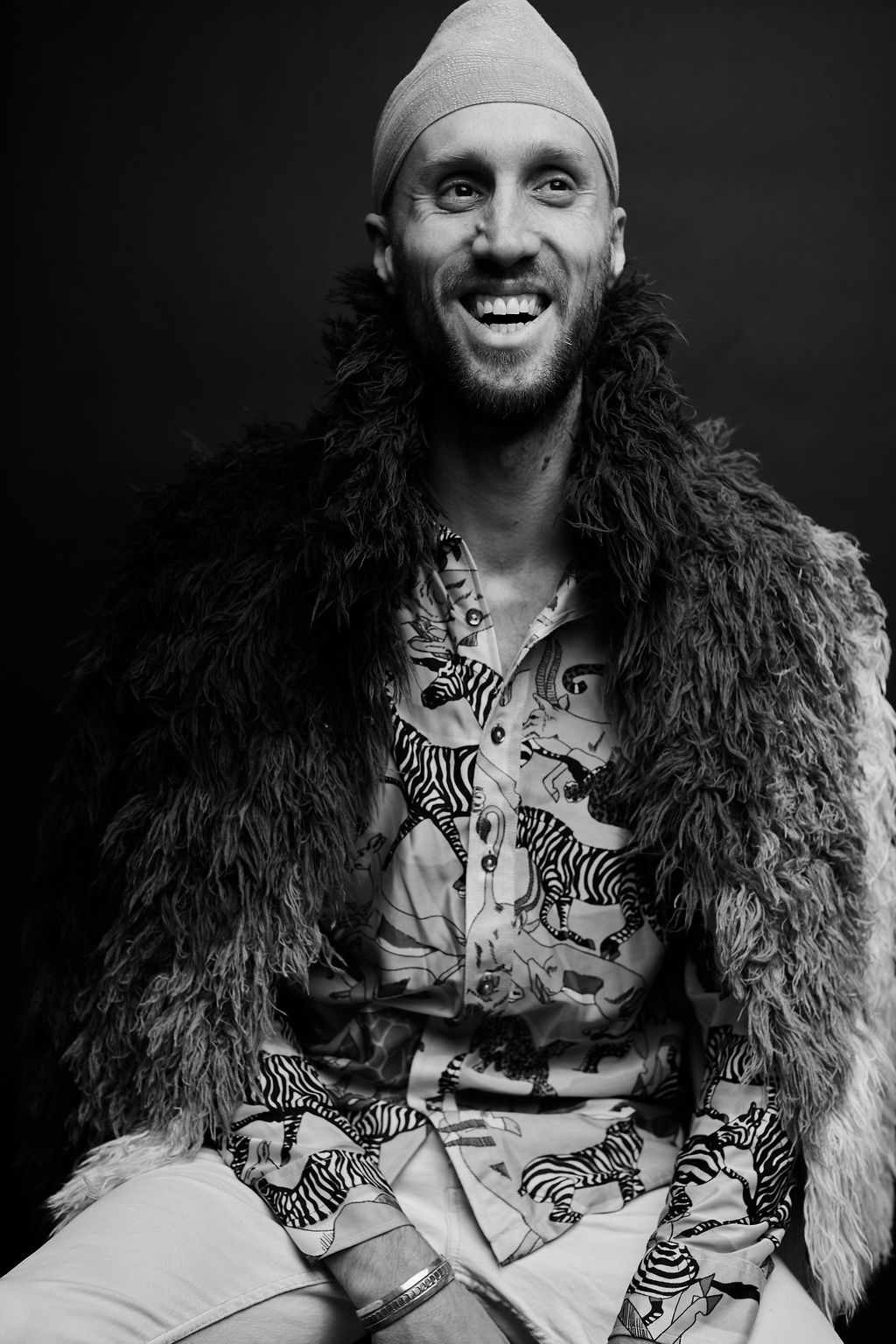 Black and white portrait with textured fur coat and patterned shirt.