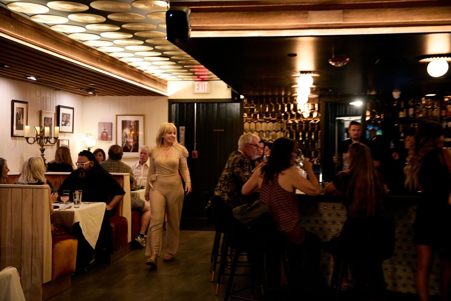Dimly lit bar interior with wooden paneling and mood lighting creates an intimate atmosphere.