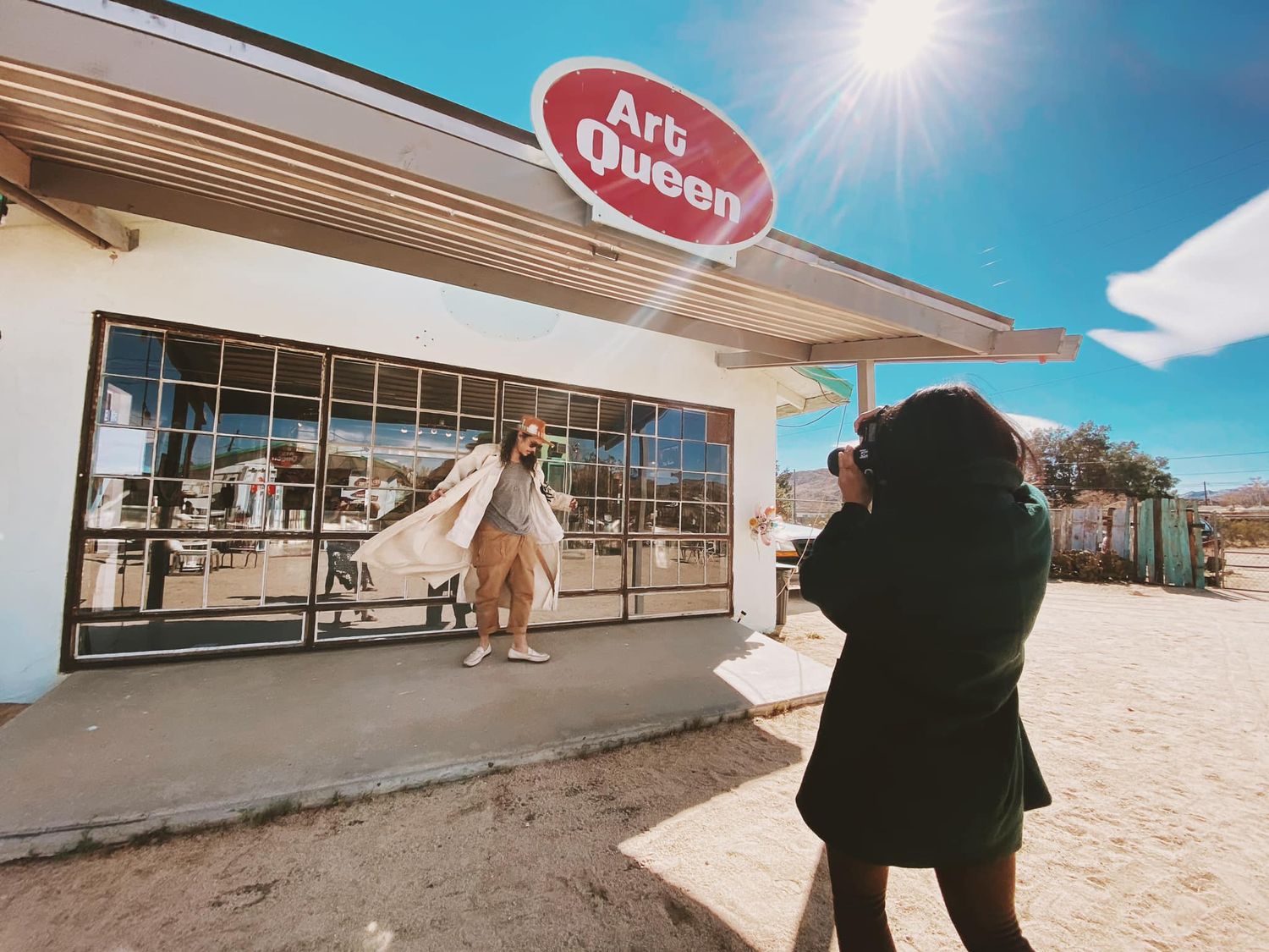 A photographer captures a scene outside a vintage ice cream shop during a bright sunny day.
