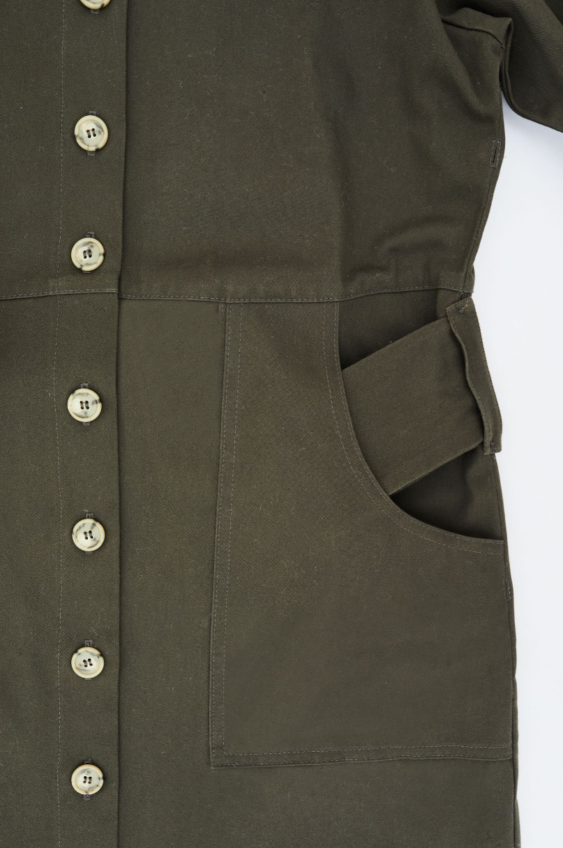 Olive green button-up dress detail showing pocket and button placket.
