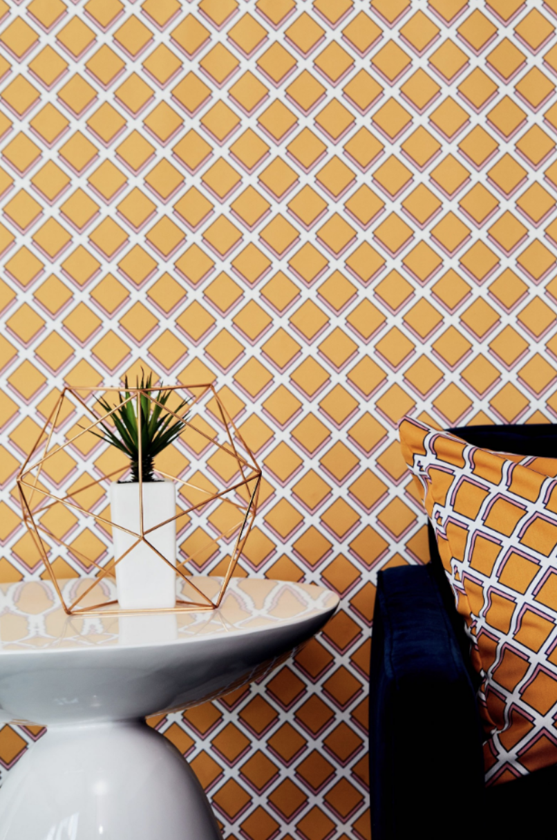 Modern geometric yellow wallpaper with hexagonal plant holder and navy cushion.