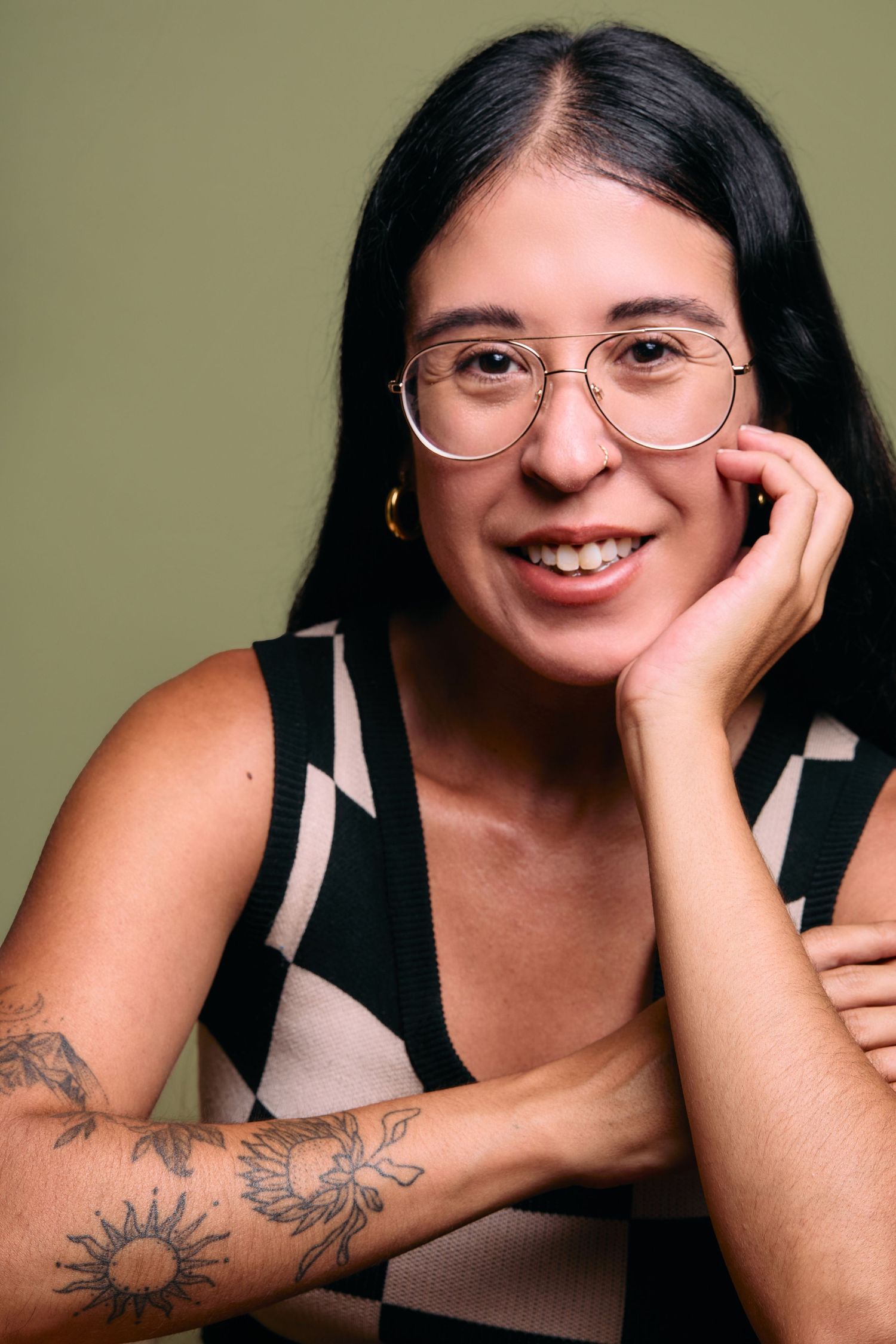 Photo series of a person in glasses wearing black, smiling and posing playfully against a neutral background.
