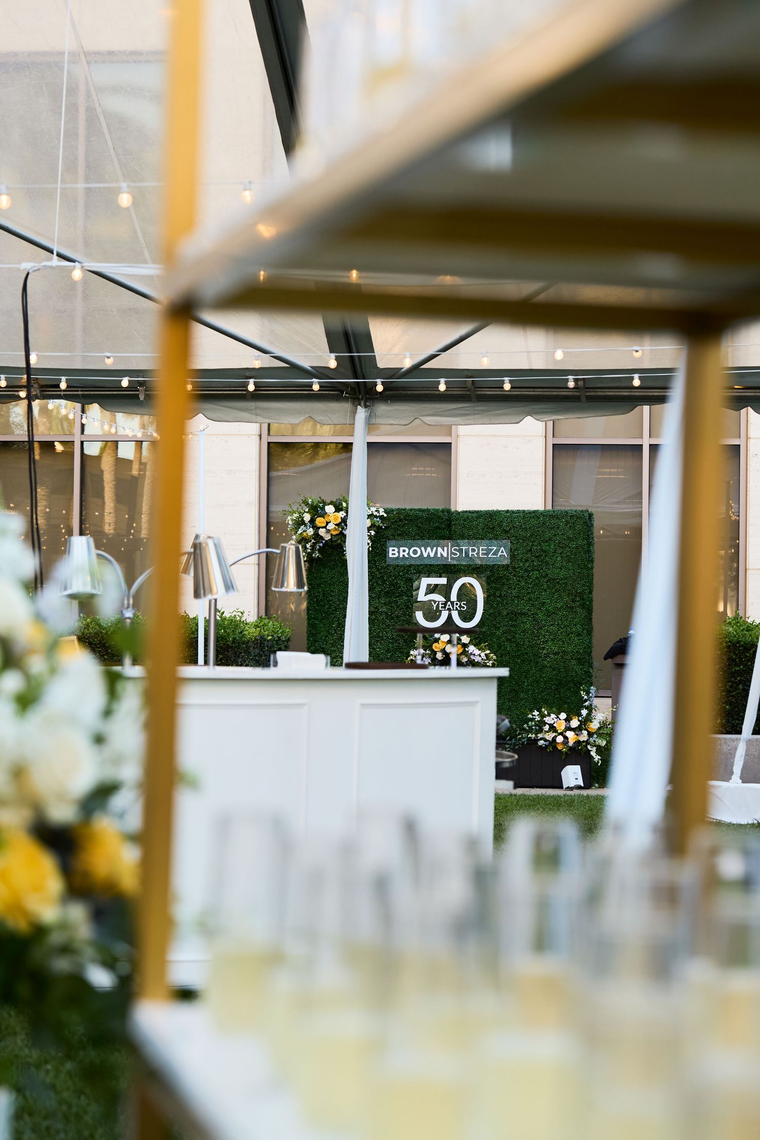 Large number 50 display with green hedge wall backdrop at an elegant party venue setting.