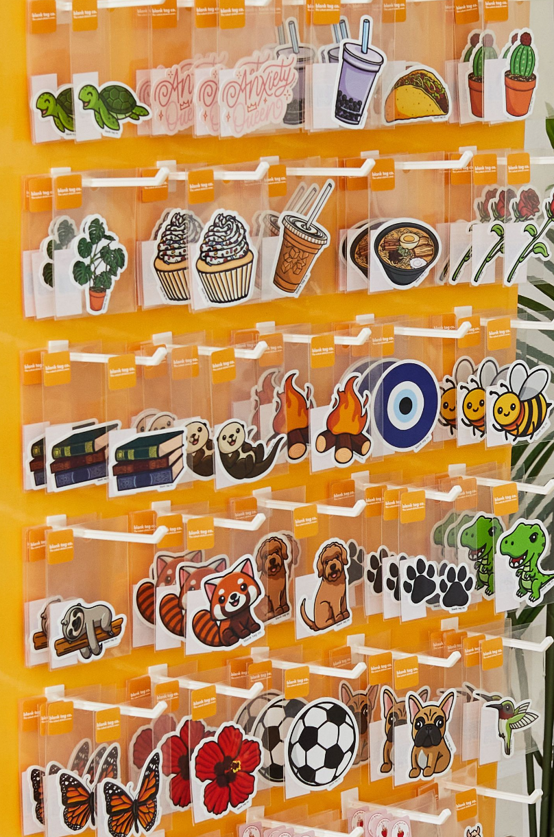 Organized display rack showing various illustrated stickers of food, sports and animals.