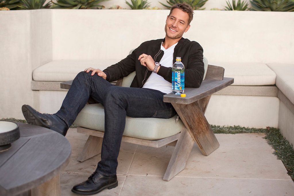 Person relaxing on outdoor patio furniture with beverage.