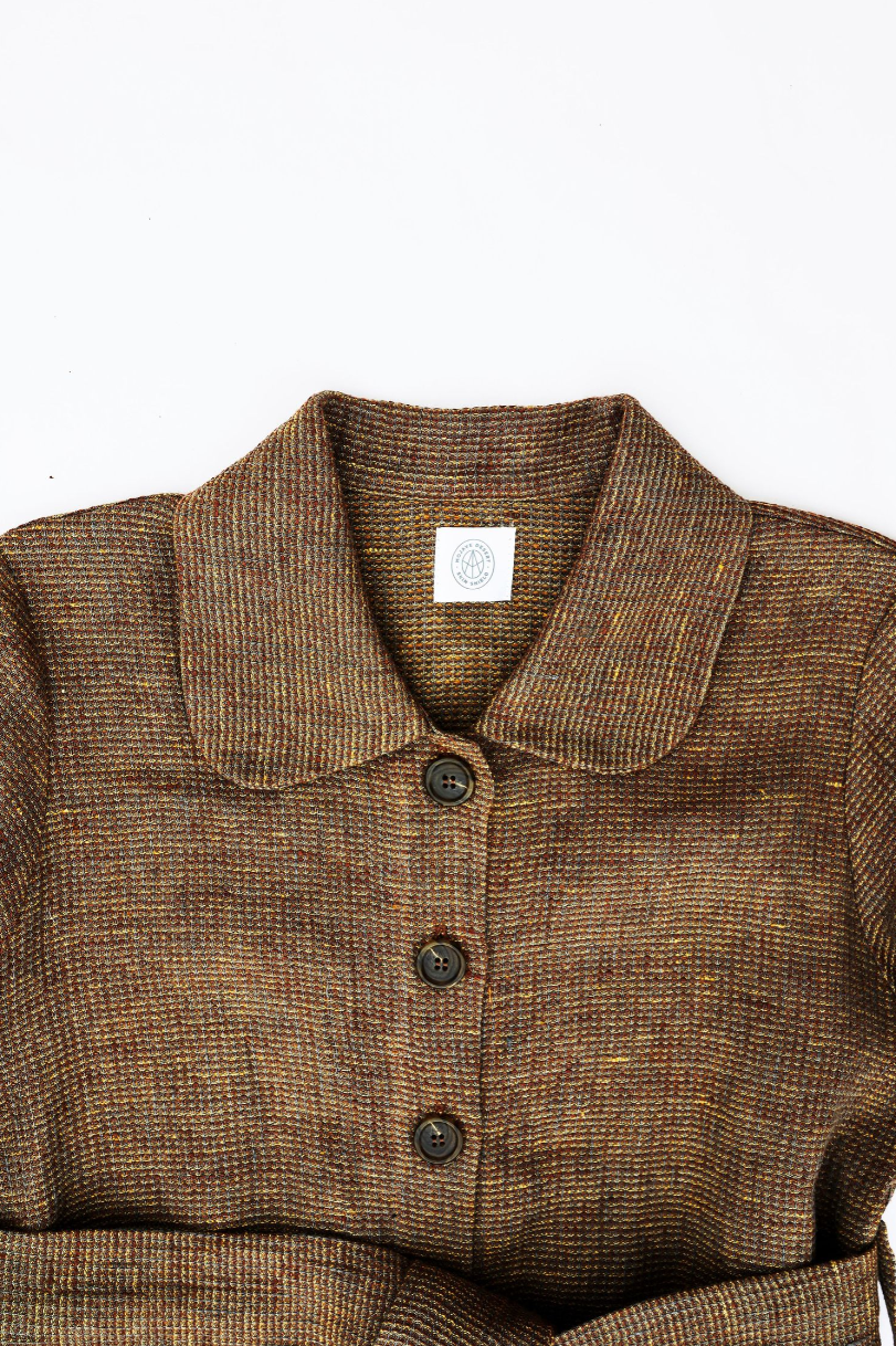 Brown tweed jacket with button closure and white label detail.