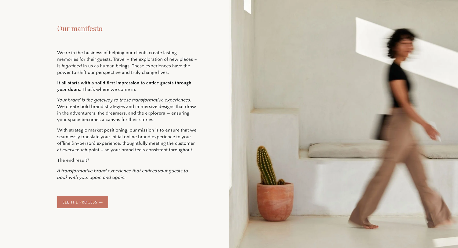 Minimalist white room interior featuring a person walking past a small potted cactus plant on the floor.