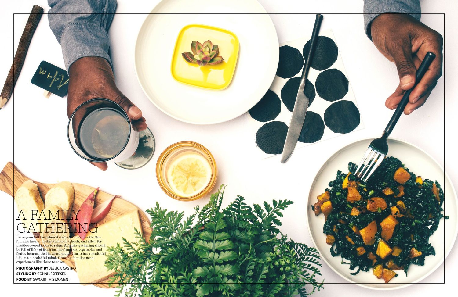 Overhead view of a table with healthy foods including fresh greens, drinks with lemon, and roasted vegetables on plates.