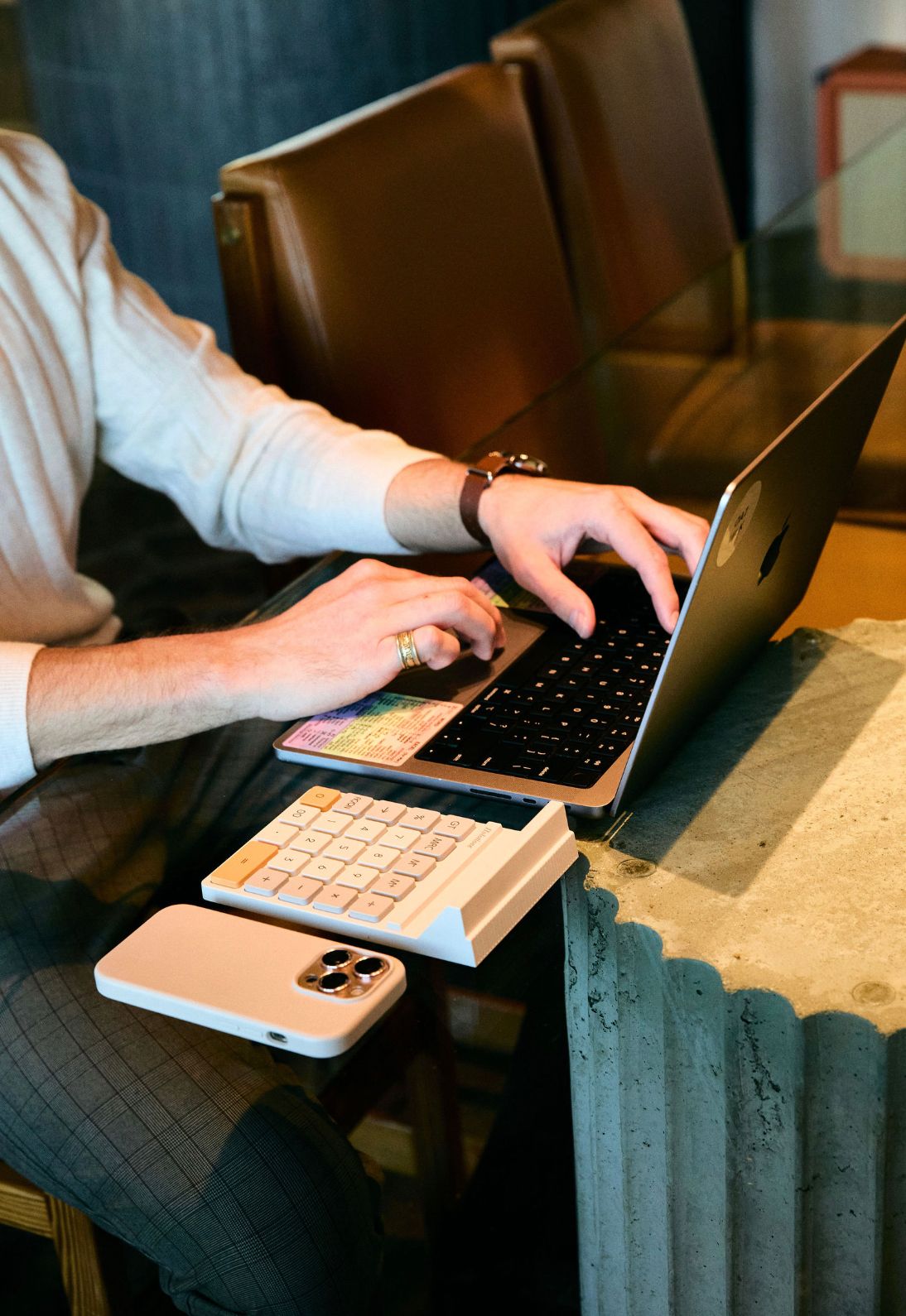 Person typing on laptop keyboard with hands visible in multiple angles showing computer work at desk.