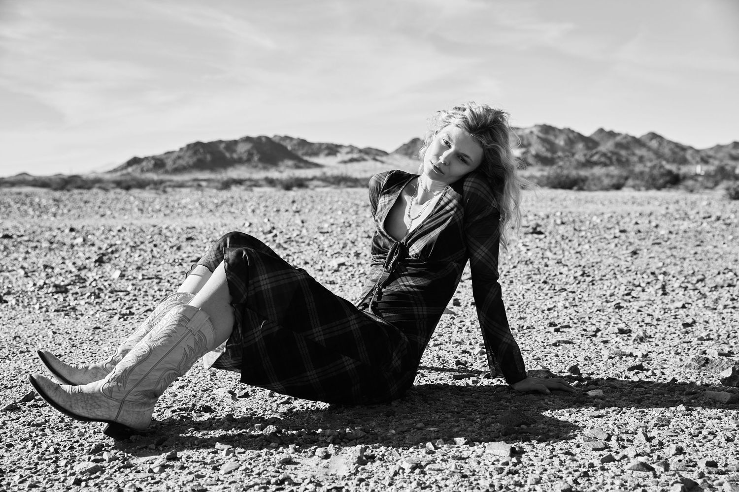 A series of black and white photographs showing someone reclining on a beach in an artistic fashion.