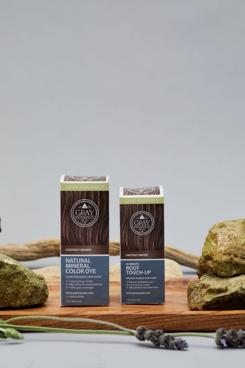 Natural hair care products in brown wooden-textured boxes displayed on stone surface with lavender sprigs.