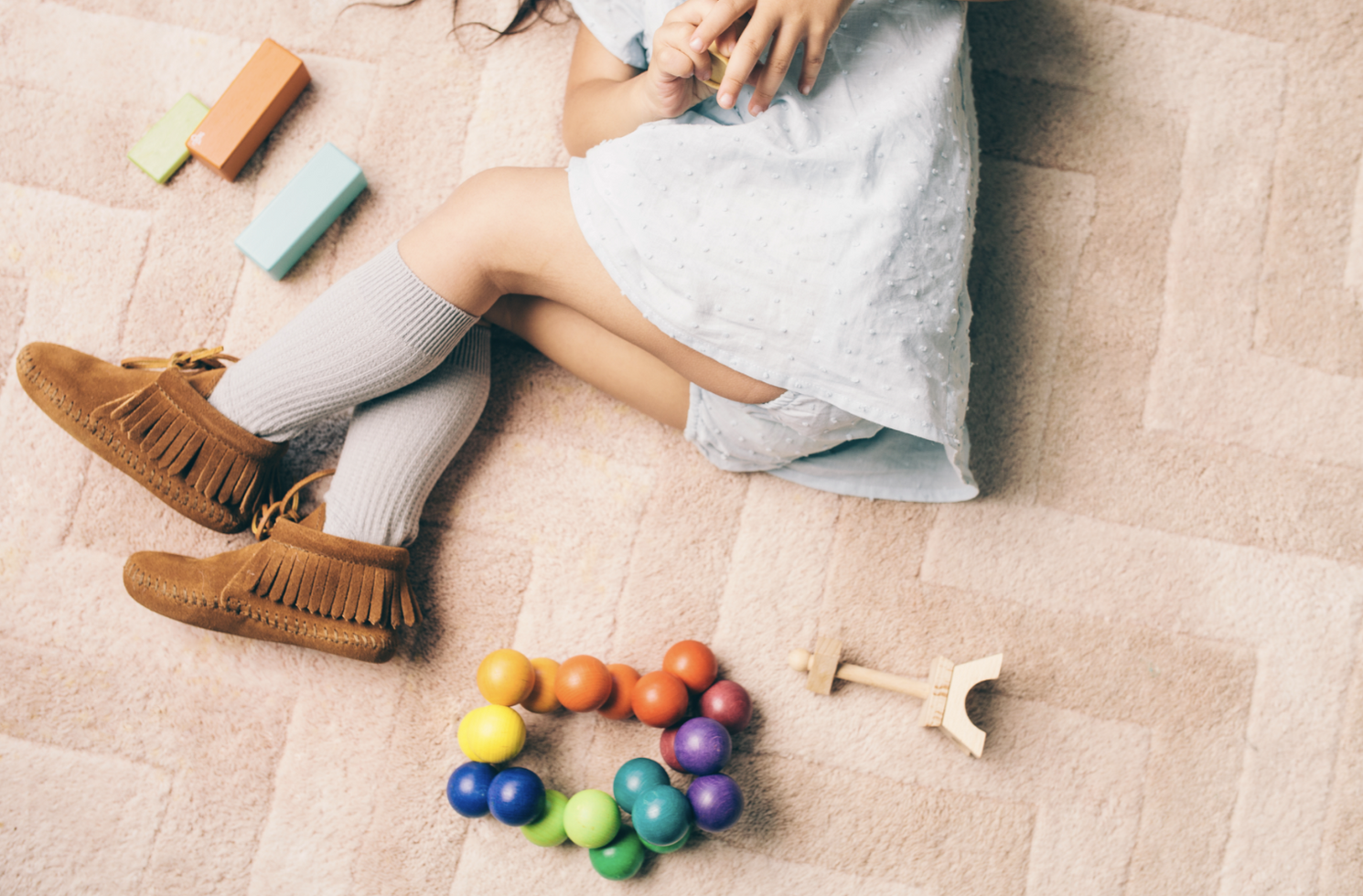Colorful Easter eggs and toys scattered on carpet next to resting feet.