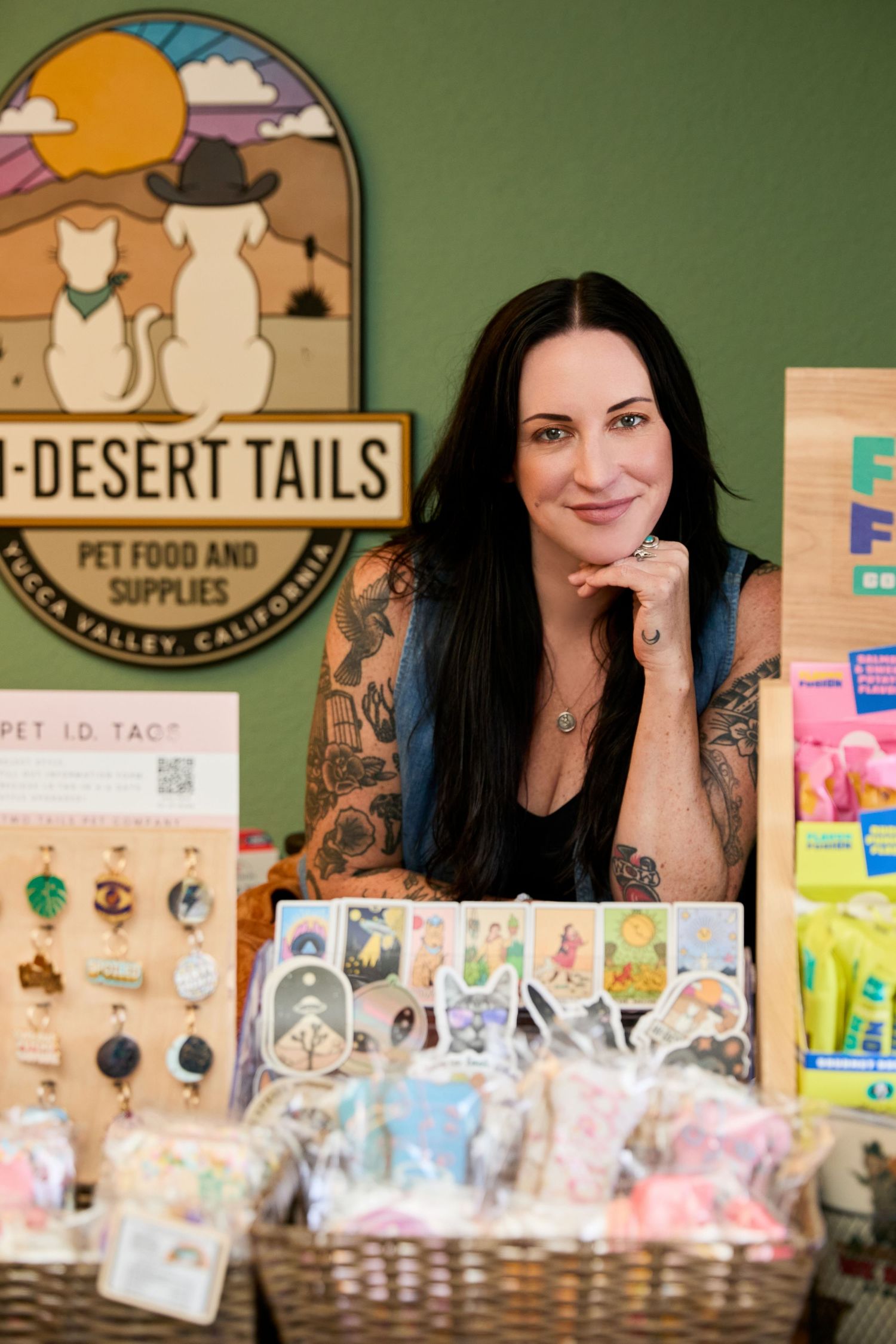 A person at a retail counter displays pet supplies and merchandise at Desert Tails pet store.