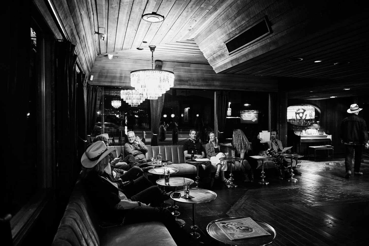 Interior of dark nightclub venue with wooden walls and chandelier lighting creating moody ambiance.