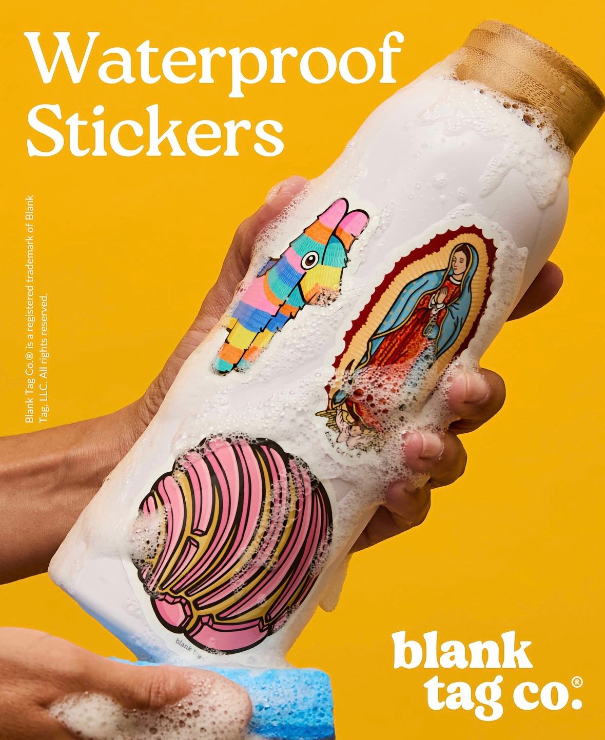 Hand washing a water bottle covered in colorful waterproof stickers including a pinata and Virgin Mary by Blank Tag Co.