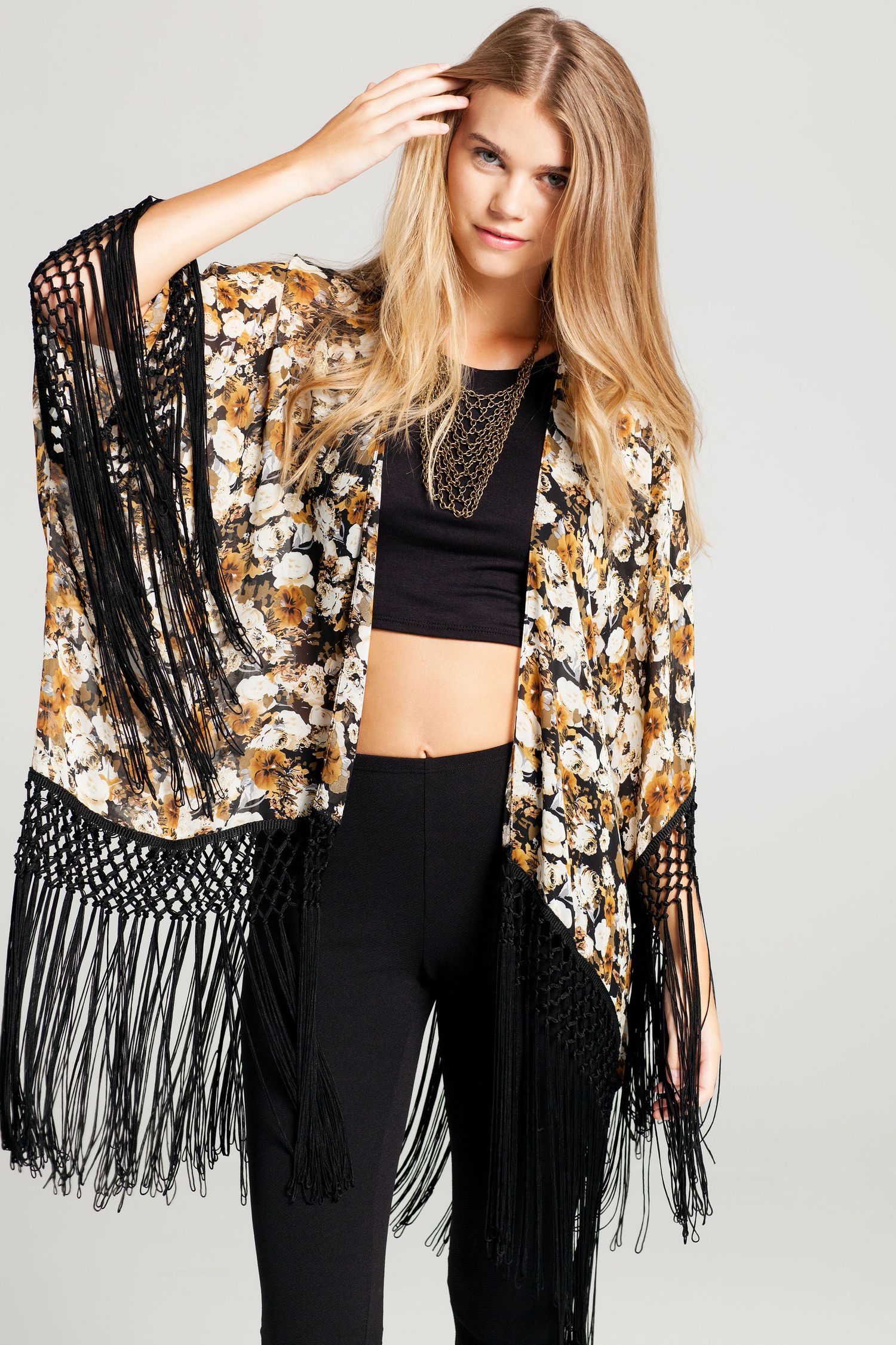 Bohemian style floral kimono with black fringe detail paired with crop top and dark pants.