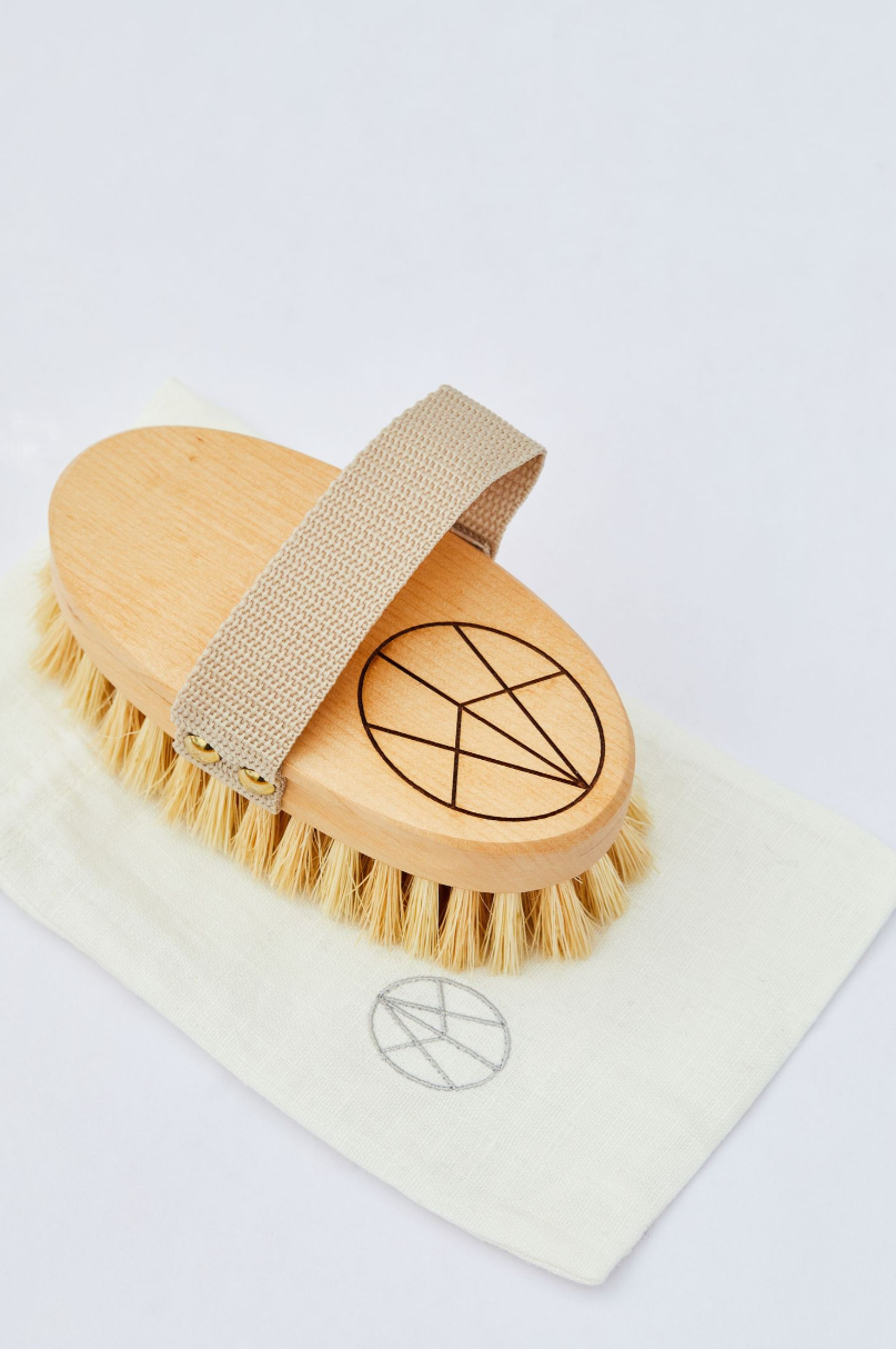 Wooden body brush with branded logo design on white background.