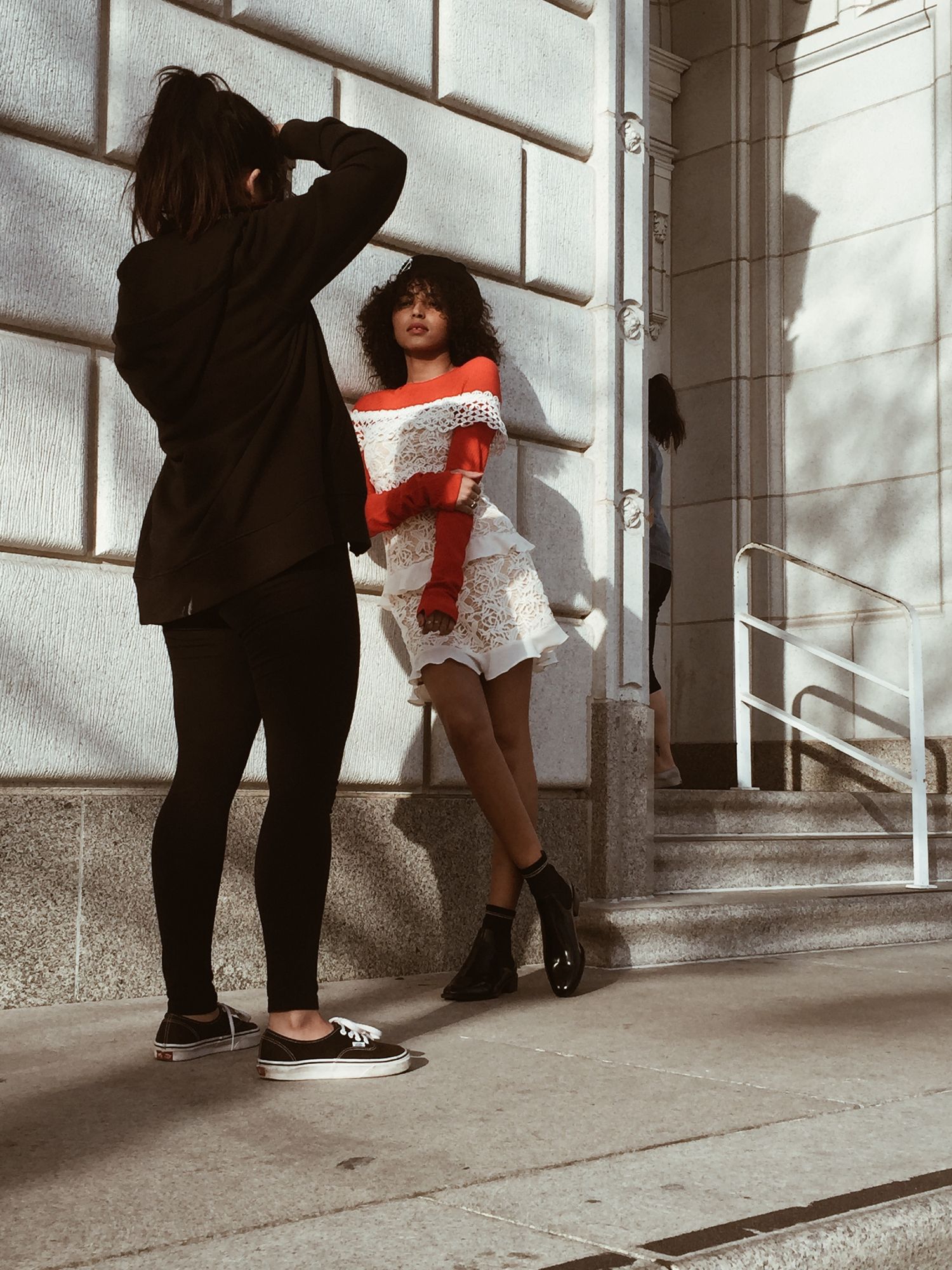 A series of black and white artistic photos showing people sitting and crouching against a building wall in urban setting.