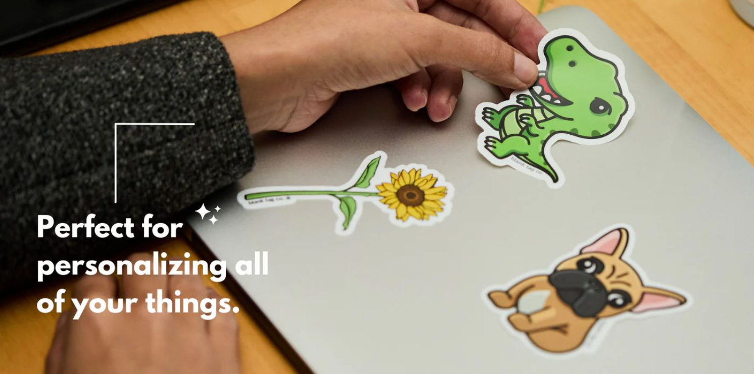 Hand placing cute dinosaur and animal stickers on a surface.