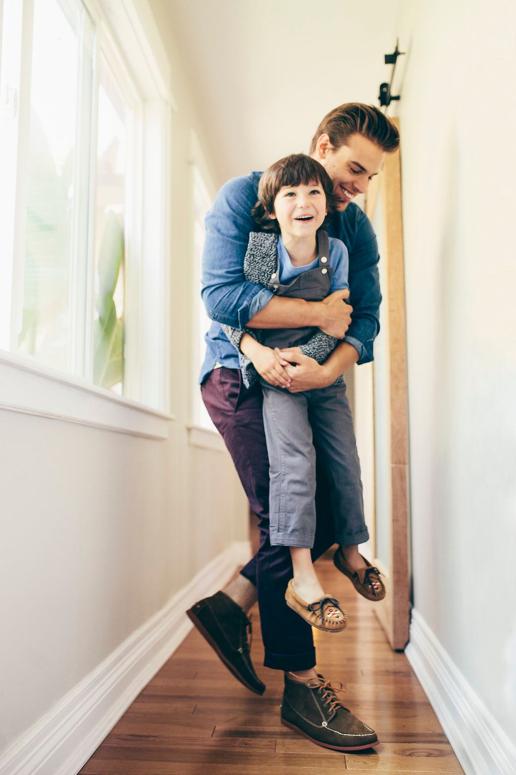 Playful moment captured in hallway showing parent and child interaction.