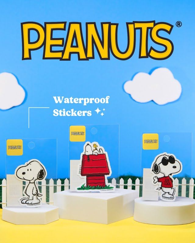 Peanuts branded waterproof stickers featuring Snoopy characters displayed on white pedestals.