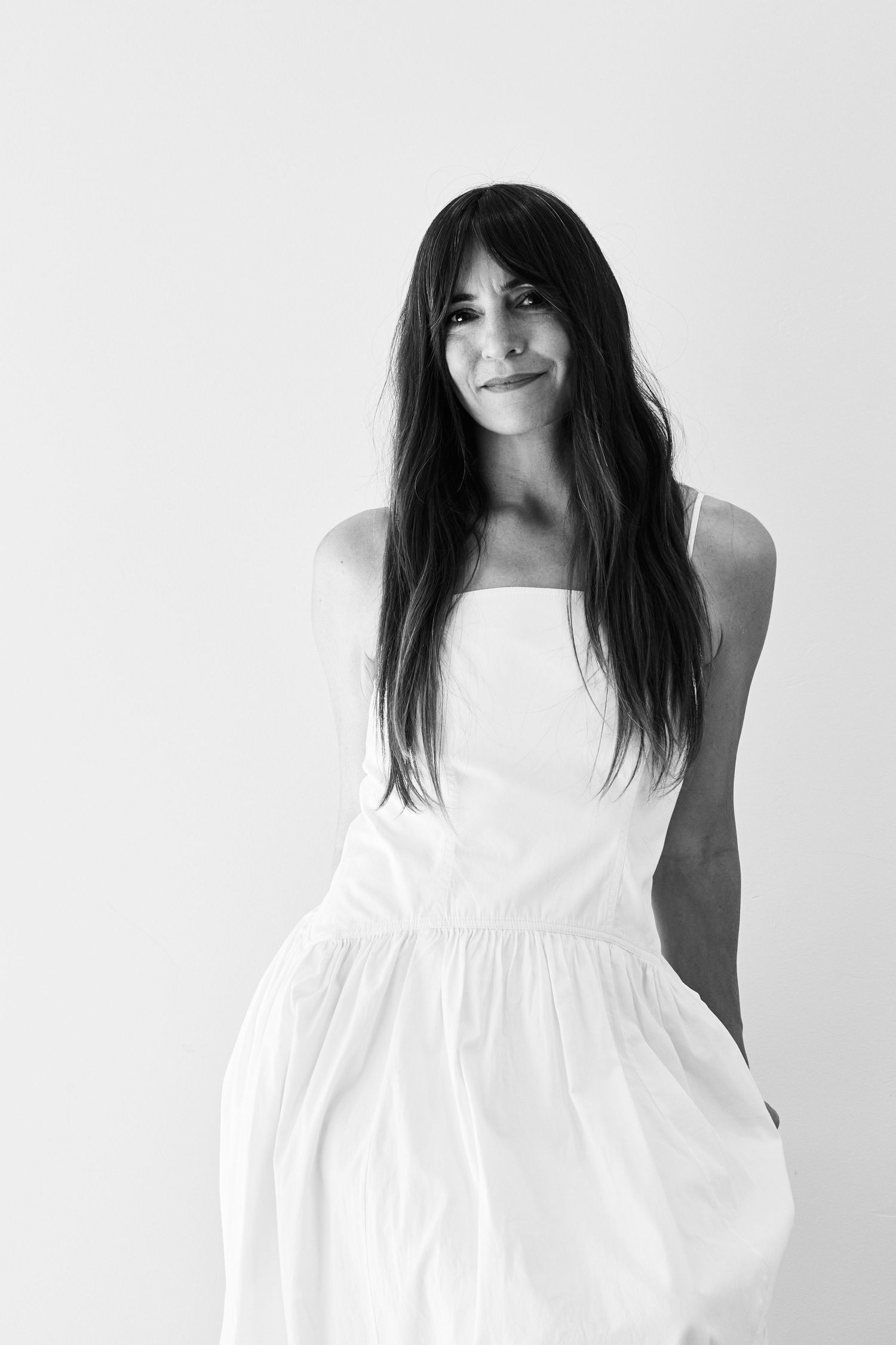 A series of three black and white portraits showing someone with dark hair wearing a white dress against a light background.
