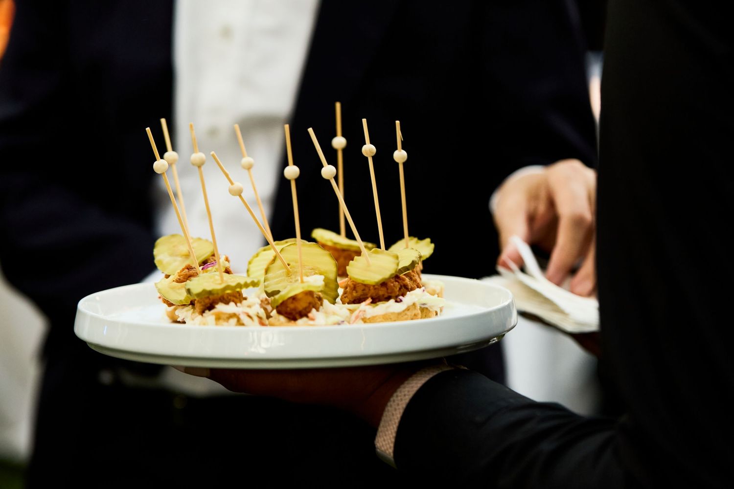 A plate of gourmet appetizers garnished with microgreens and served on toothpicks.