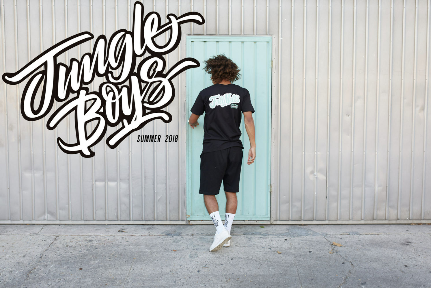 Person jumping in front of wall with 'Jungle Boys' graffiti text in urban setting.