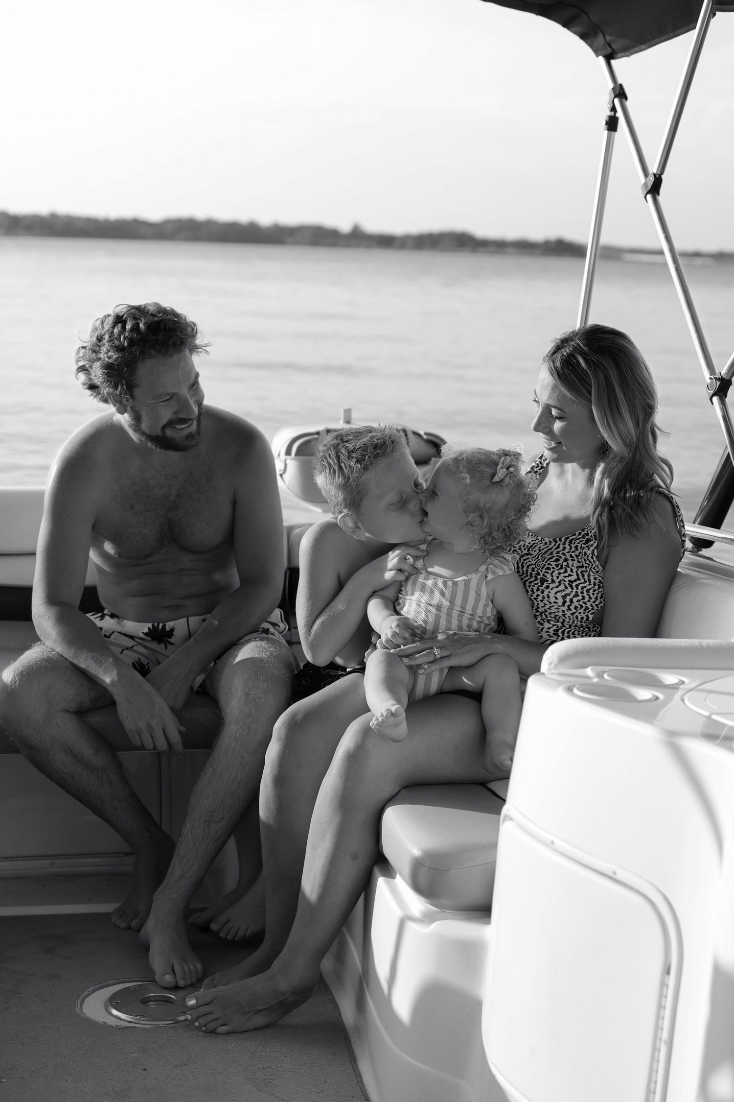 Family relaxing together on a boat during a sunny day on the water.