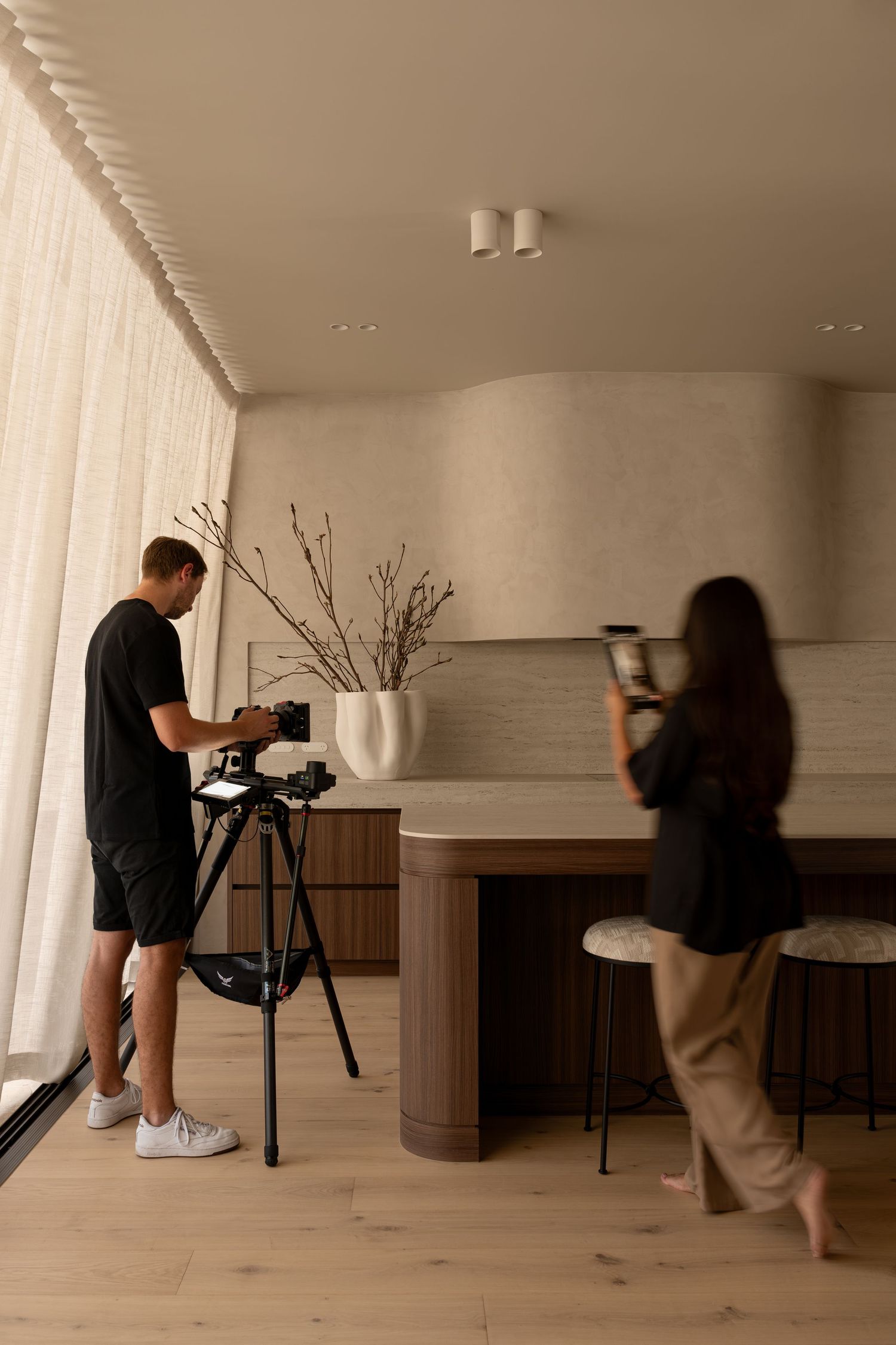 Behind-the-scenes photo sequence showing camera setup and filming process in a minimalist interior space.