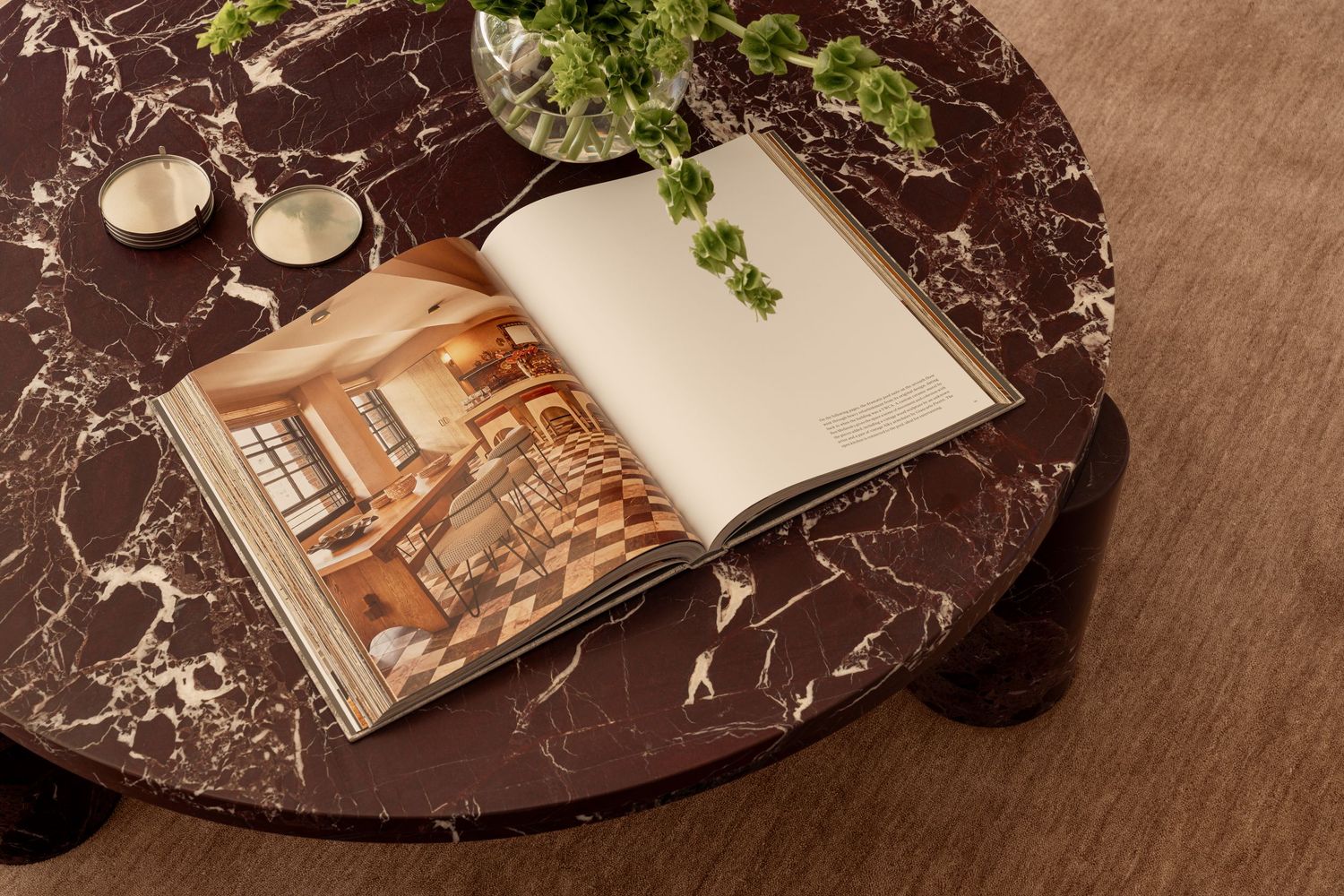 Marble coffee table styled with fresh herbs, white ceramics, and decorative books arranged in an elegant display.
