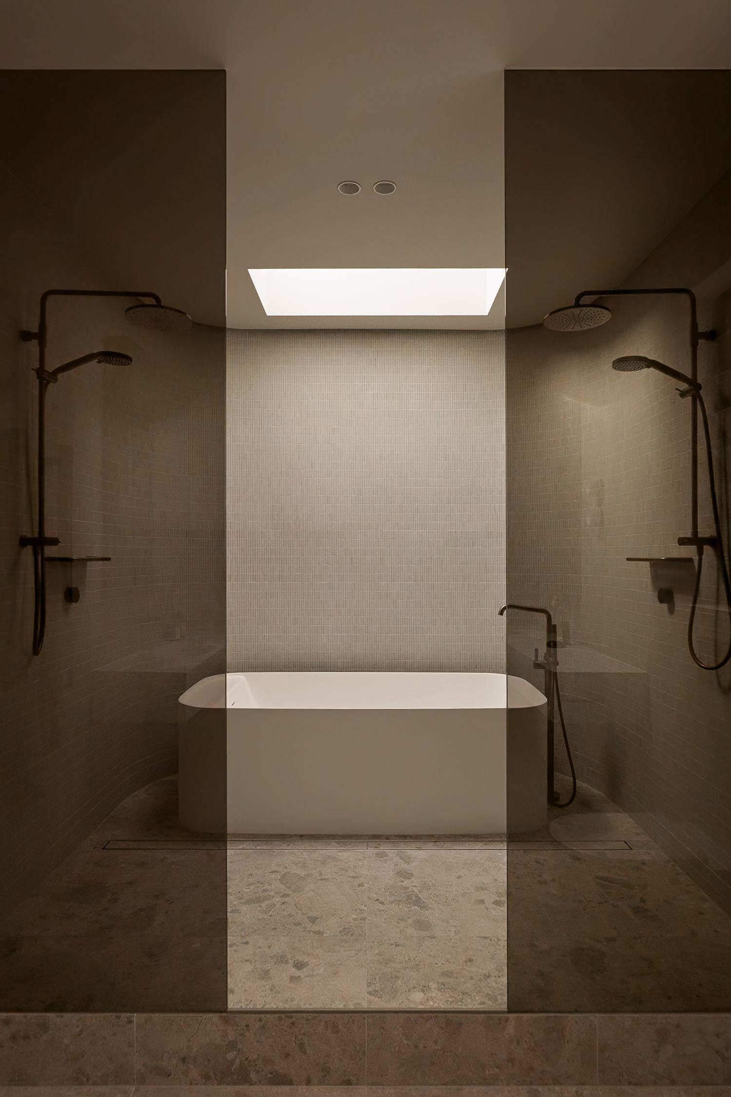 Minimalist bathroom interior with freestanding bathtub and shower fixtures shown in sepia tones through multiple panels.