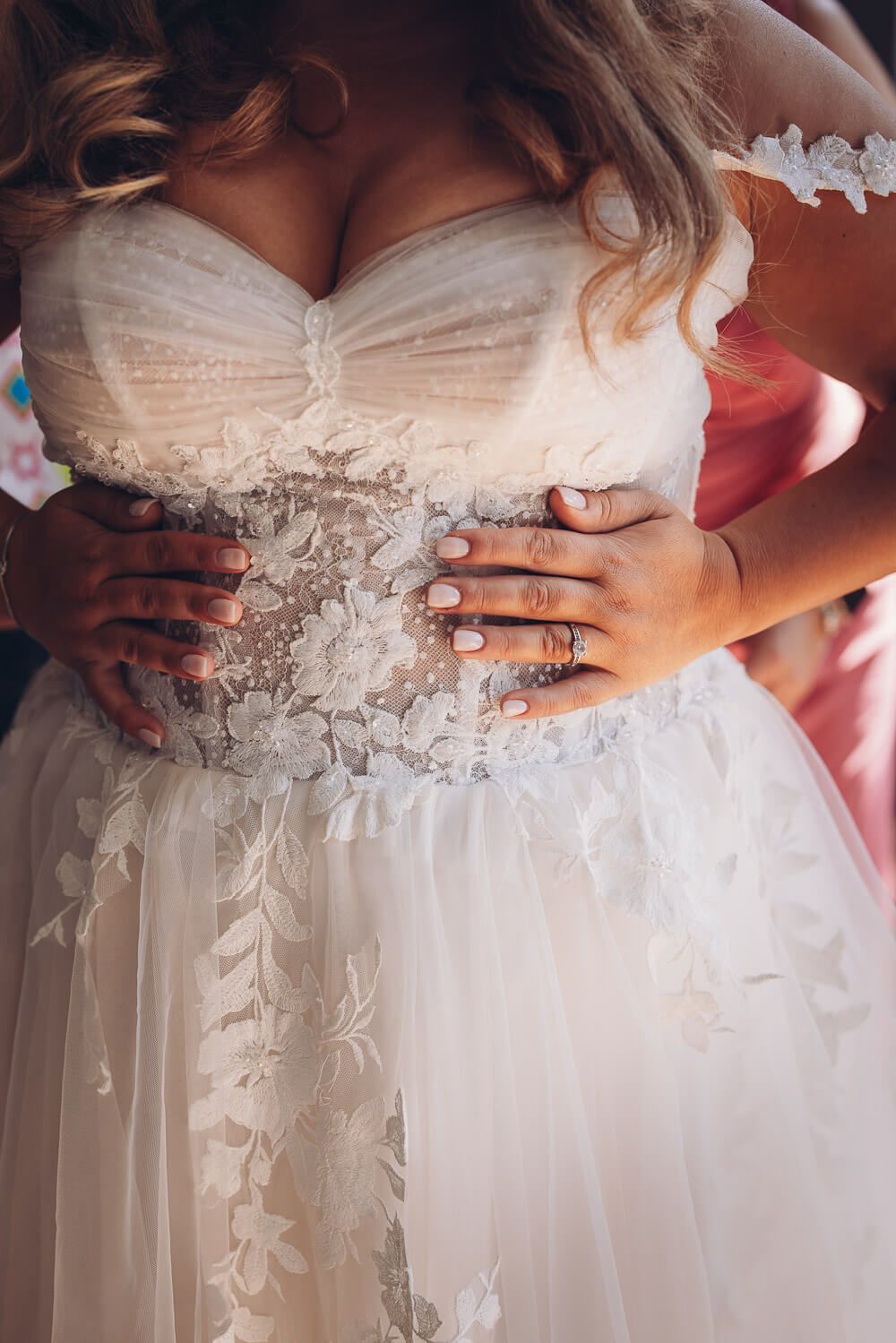 Detailaufnahme von Brautkleid mit Spitze und Händen mit Ehering. Brautpaarshooting in Hannover